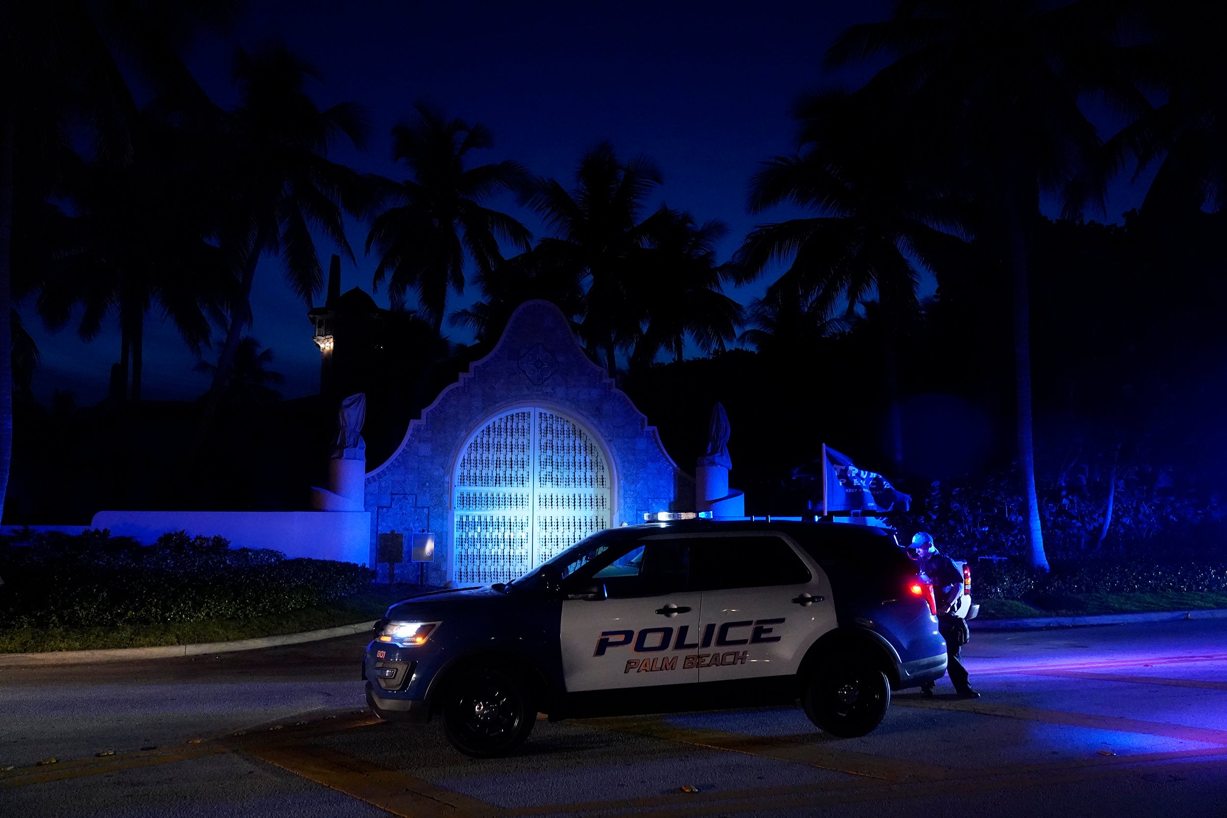 Police stand outside an entrance to former President Donald Trump's Mar-a-Lago estate, Monday, Aug. 8, 2022, in Palm Beach, Fla. Trump said in a lengthy statement that the FBI was conducting a search of his Mar-a-Lago estate and asserted that agents had broken open a safe. (AP Photo/Wilfredo Lee)