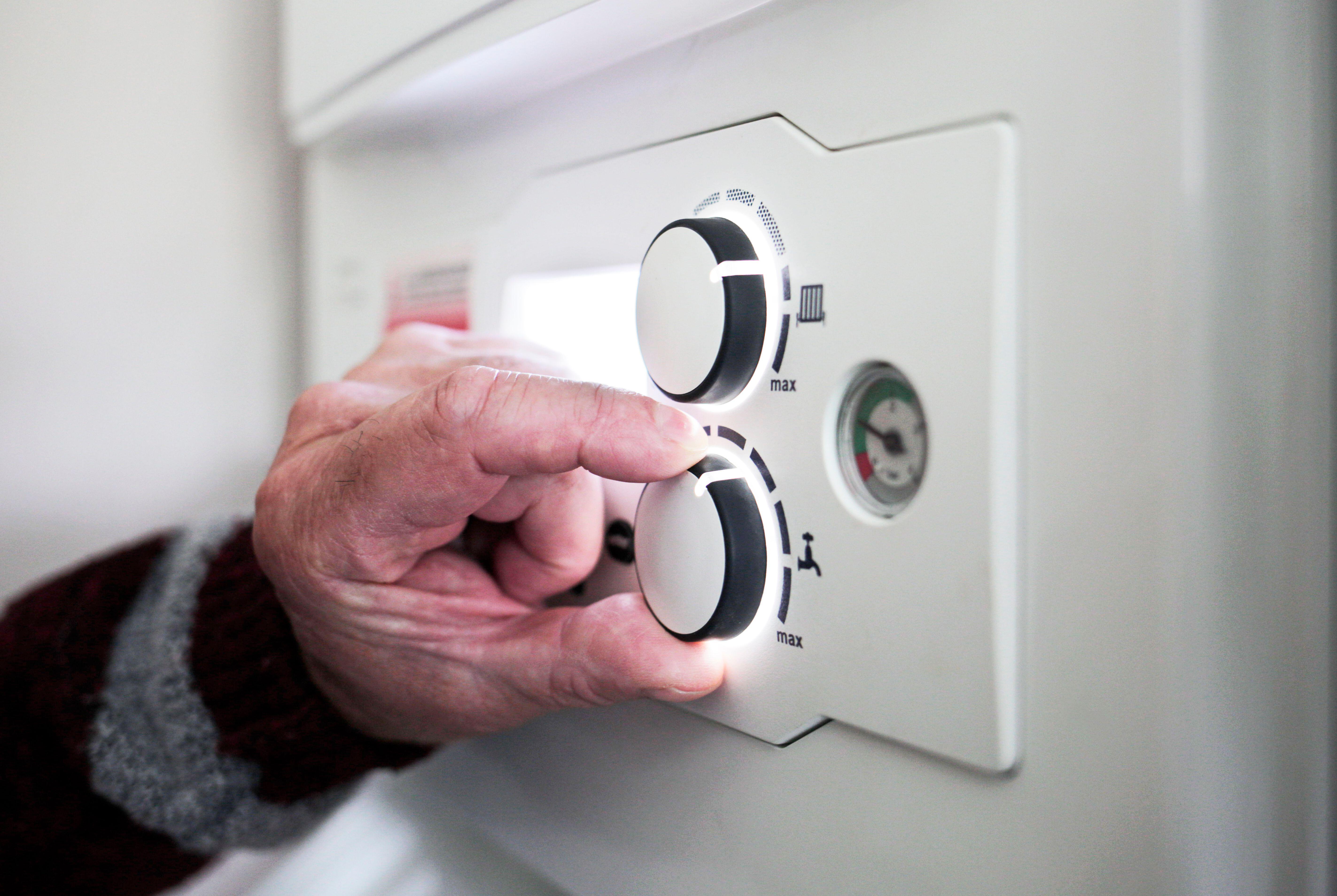 2GY56Y9 A pensioner adjusting the temperature control on his combi boiler. Redcar, UK. 26/5/2021. Photograph: Stuart Boulton.