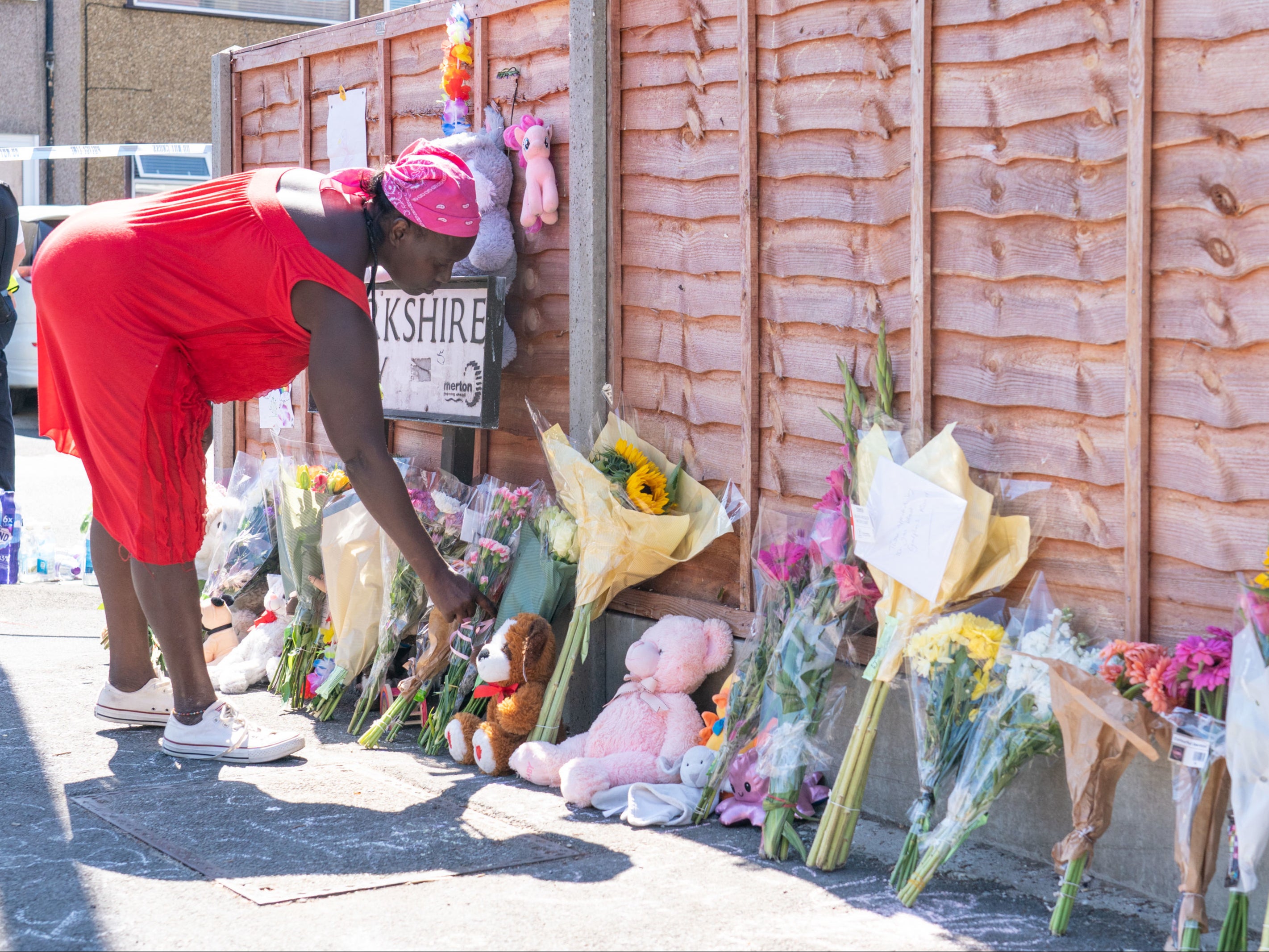 A woman lays flowers near the scene of the wreckage