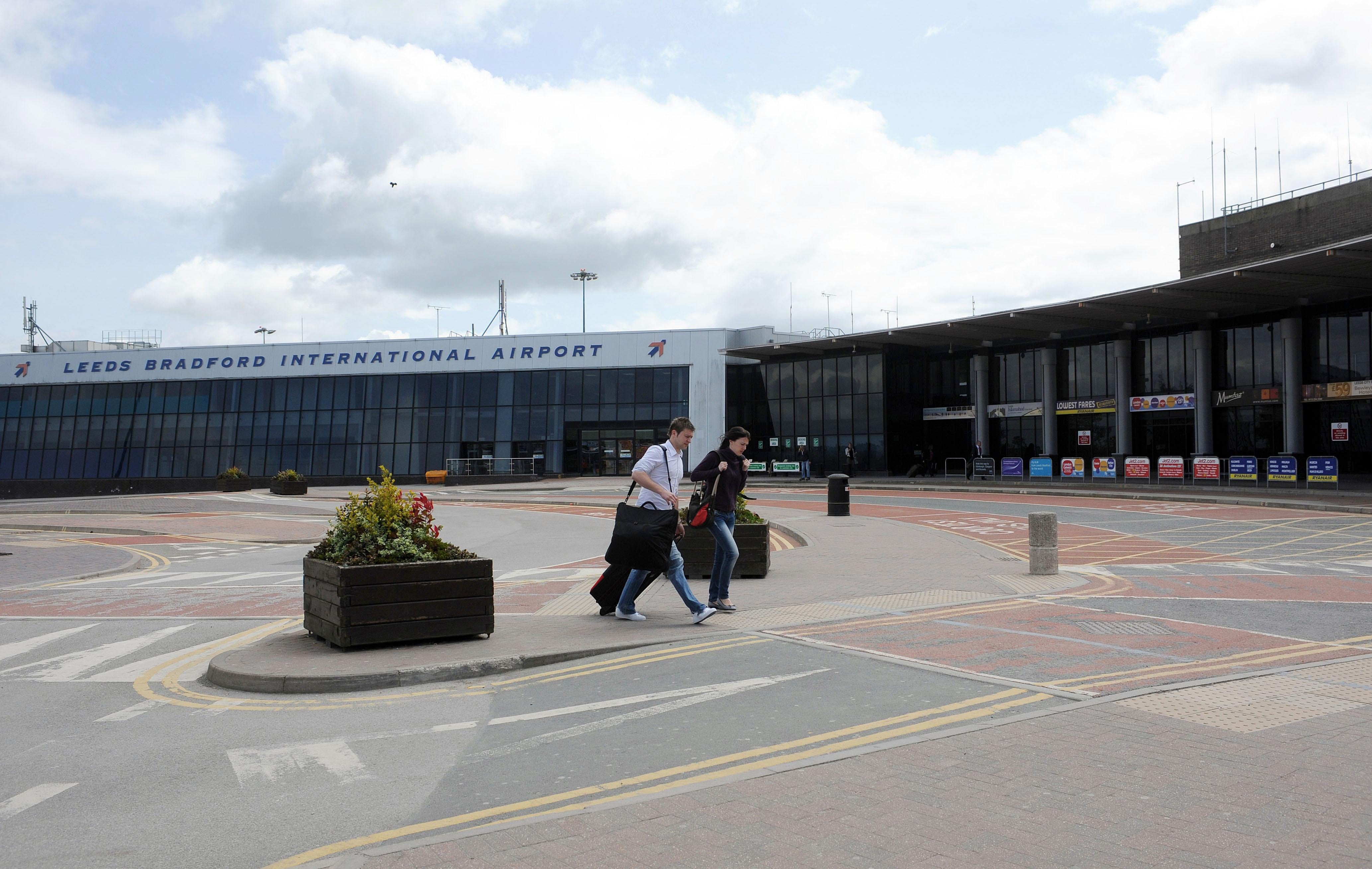 Two passengers arrive at Leeds Bradford Airport (Anna Gowthorpe/PA)