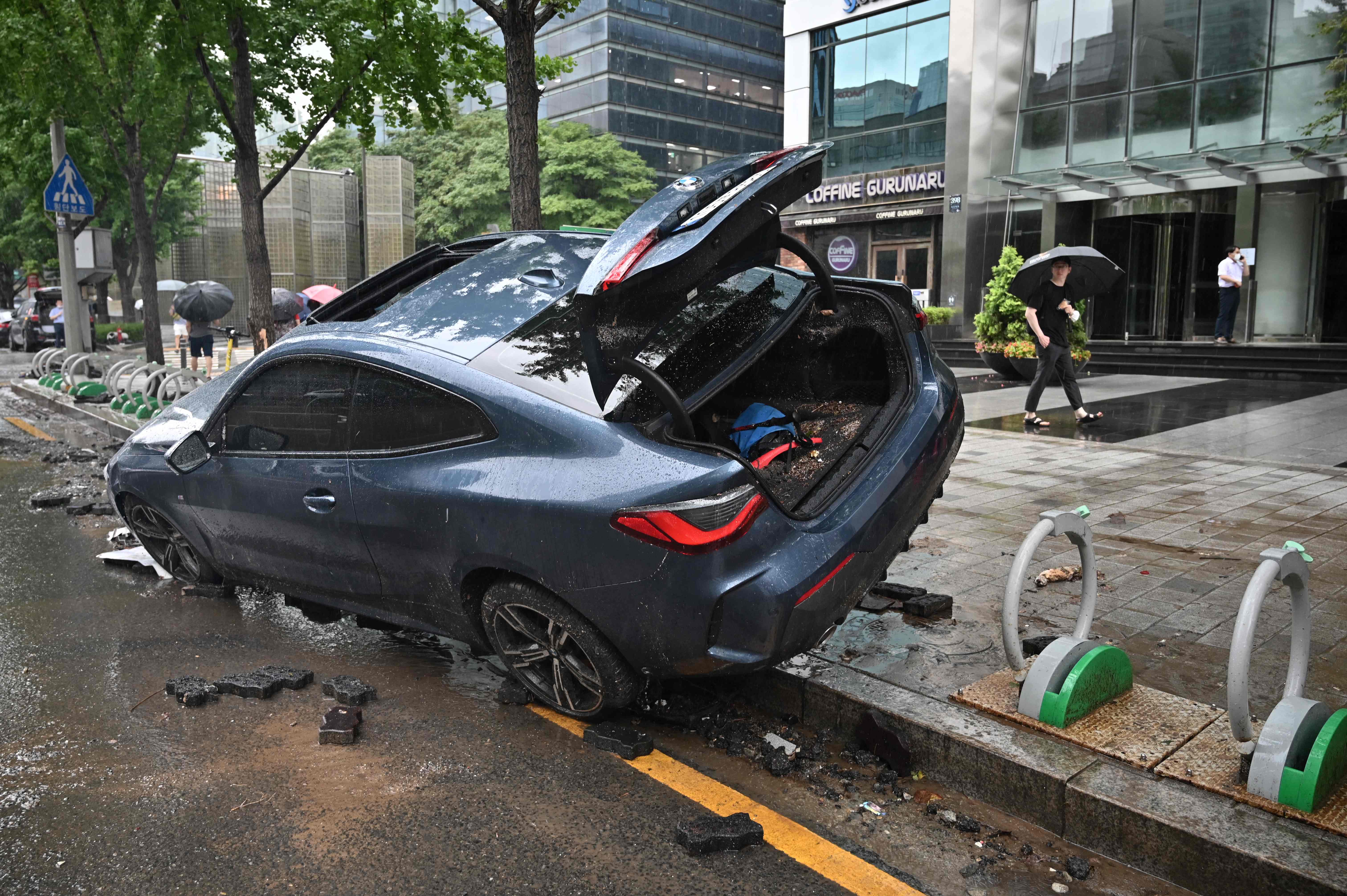 A car damaged by flood water is seen on the street after heavy rainfall at Gangnam district