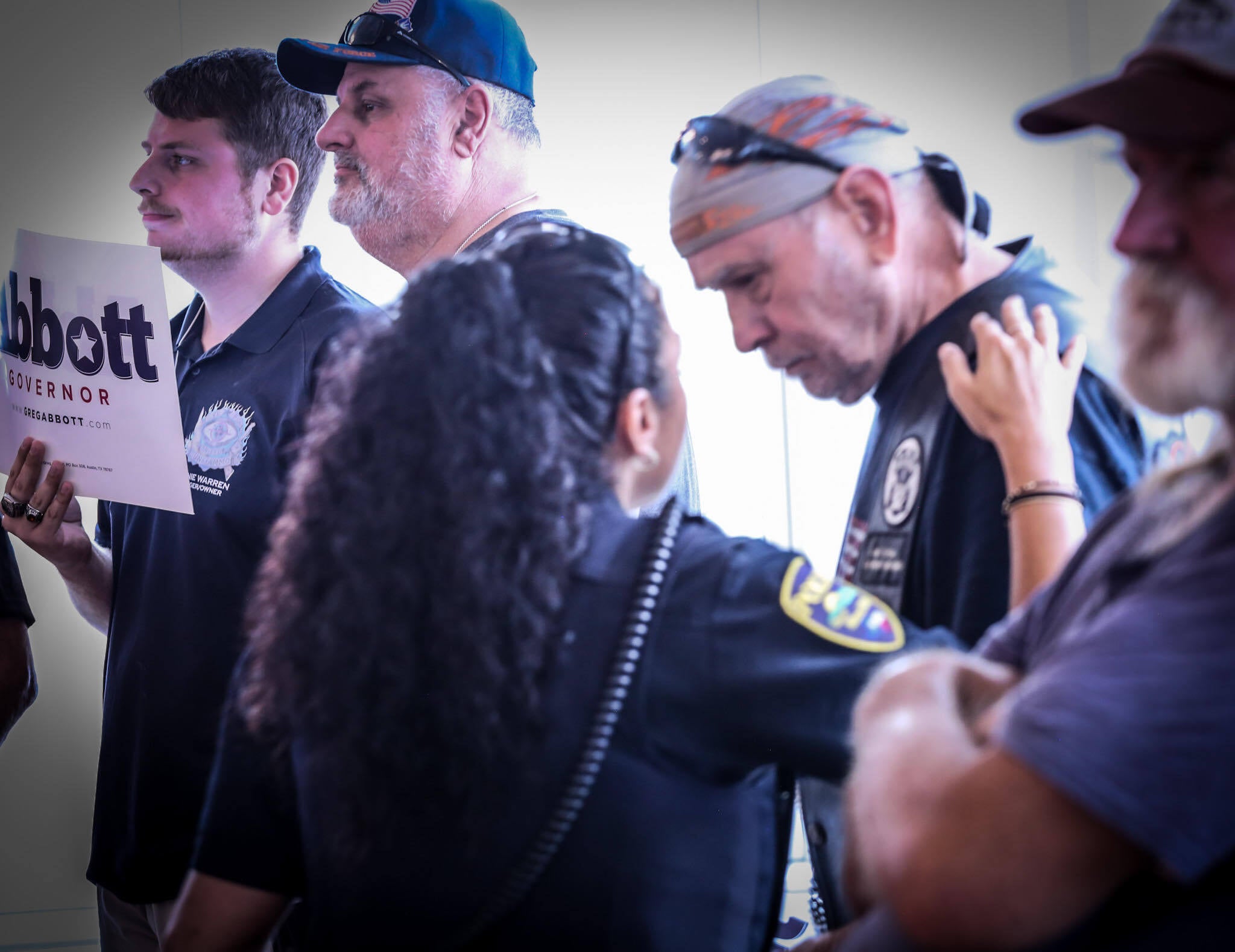 A police officer speaks to man attending Beto O’Rourke’s town hall meeting in Mineral Wells, Texas