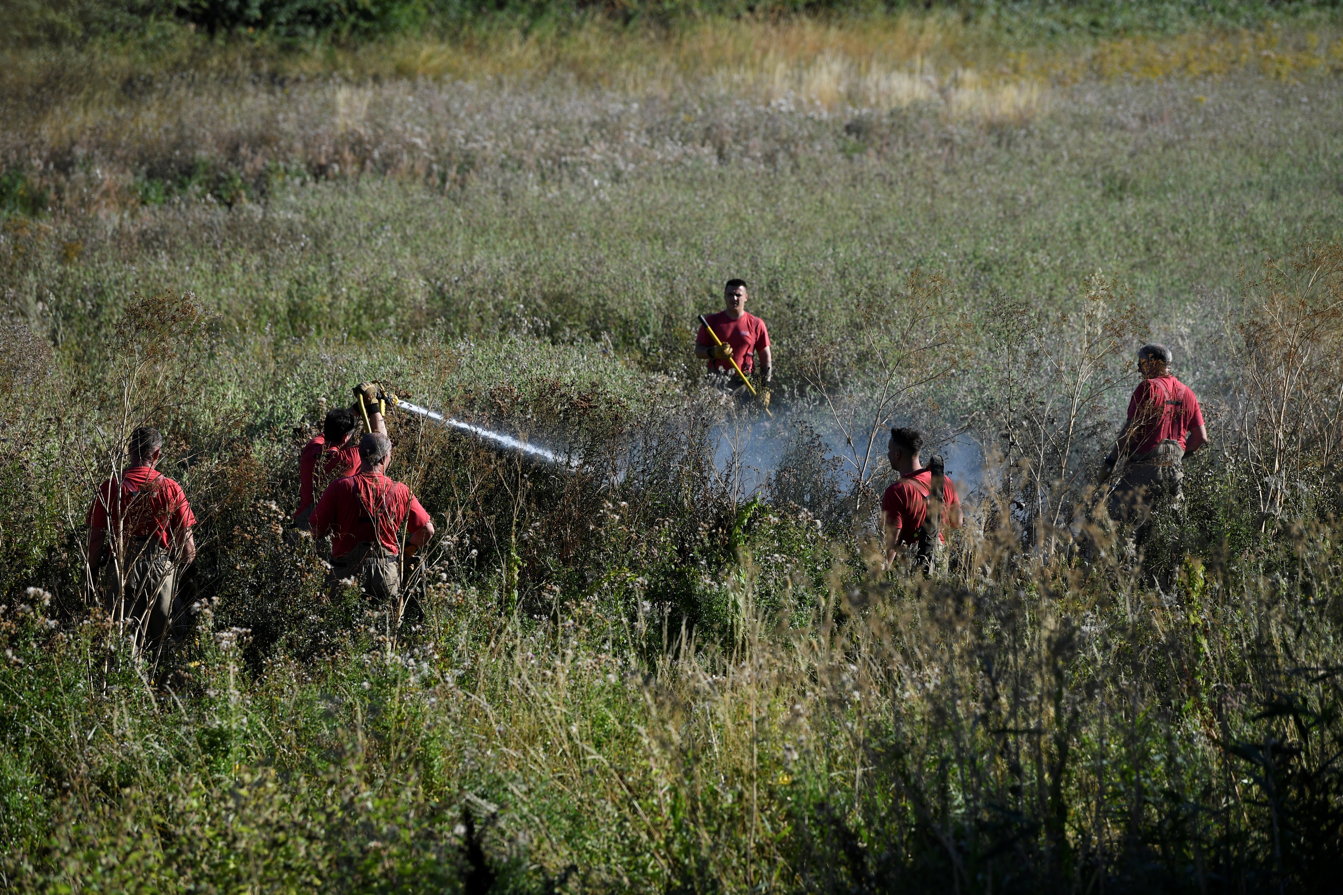 Firefighters attend to a fire, following a long period of hot weather and little rain, in Rainham, Essex