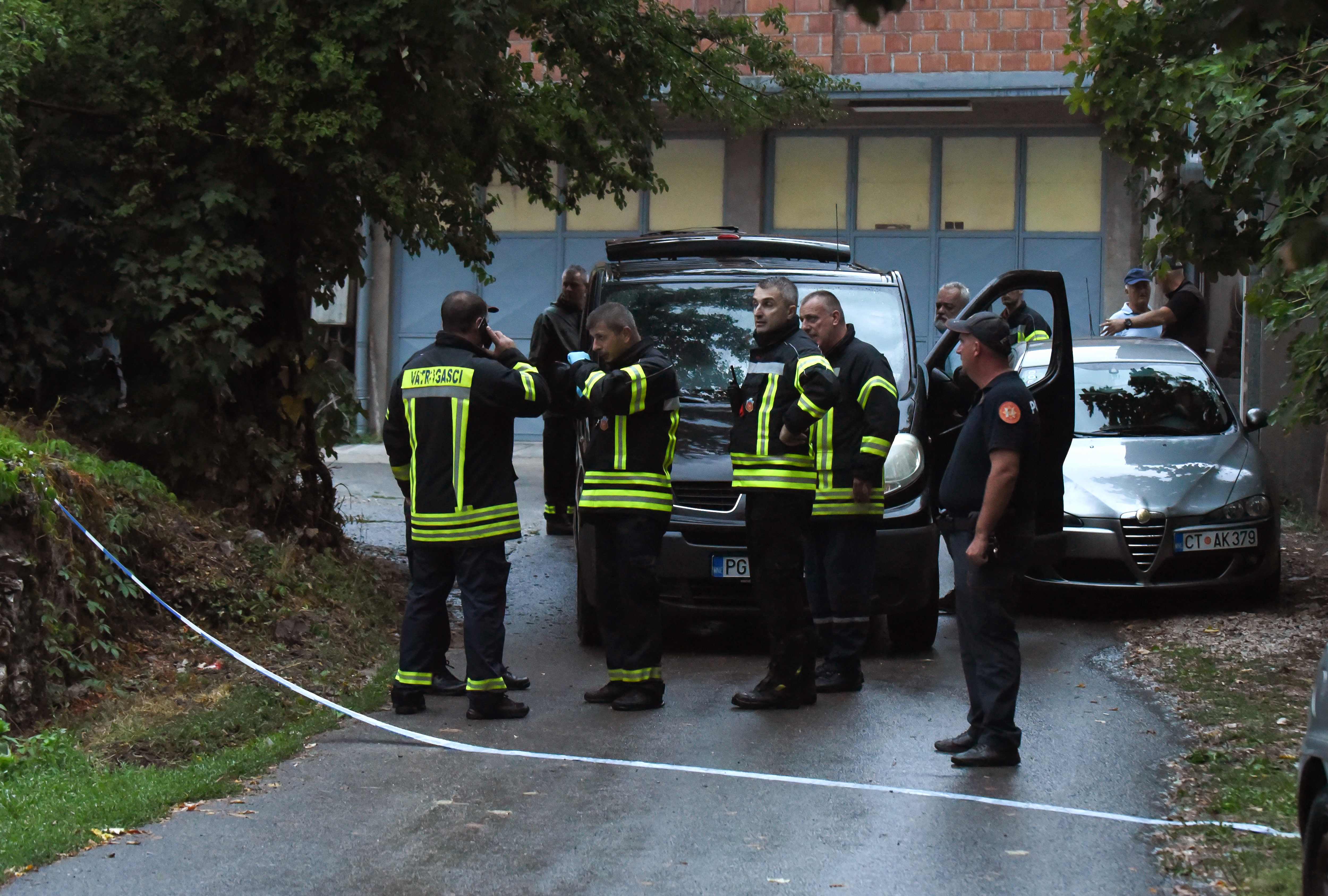 Emergency service personnel stand by near the scene of the shooting