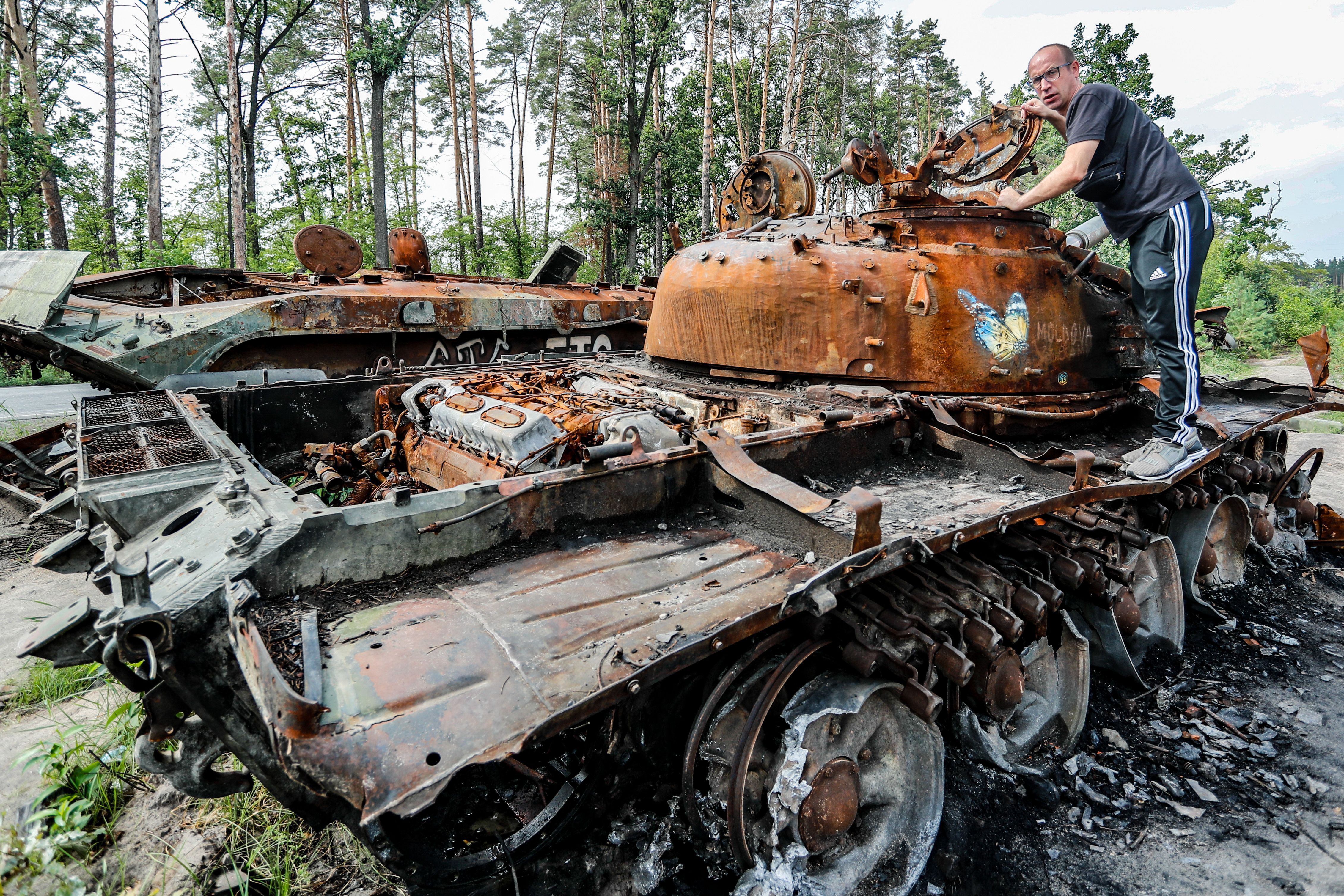 A man surveys a destroyed Russian tank in Bucha Oblast. Moscow continues to bear down on Ukraine with ferocity especially in Donetsk, Luhansk, Kharkiv and Kherson