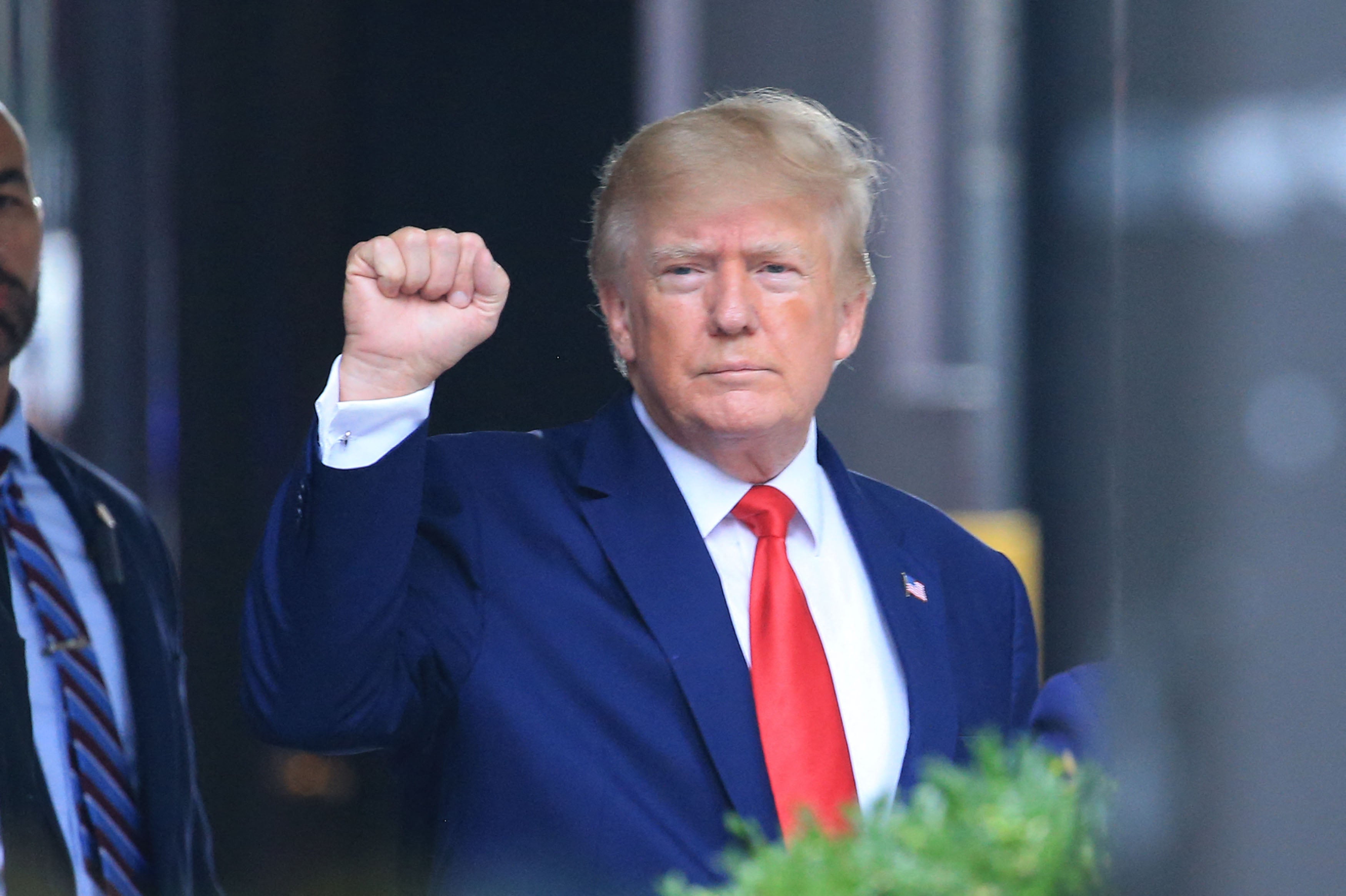 Former US President Donald Trump raises his fist while walking to a vehicle outside of Trump Tower in New York City on August 10, 2022