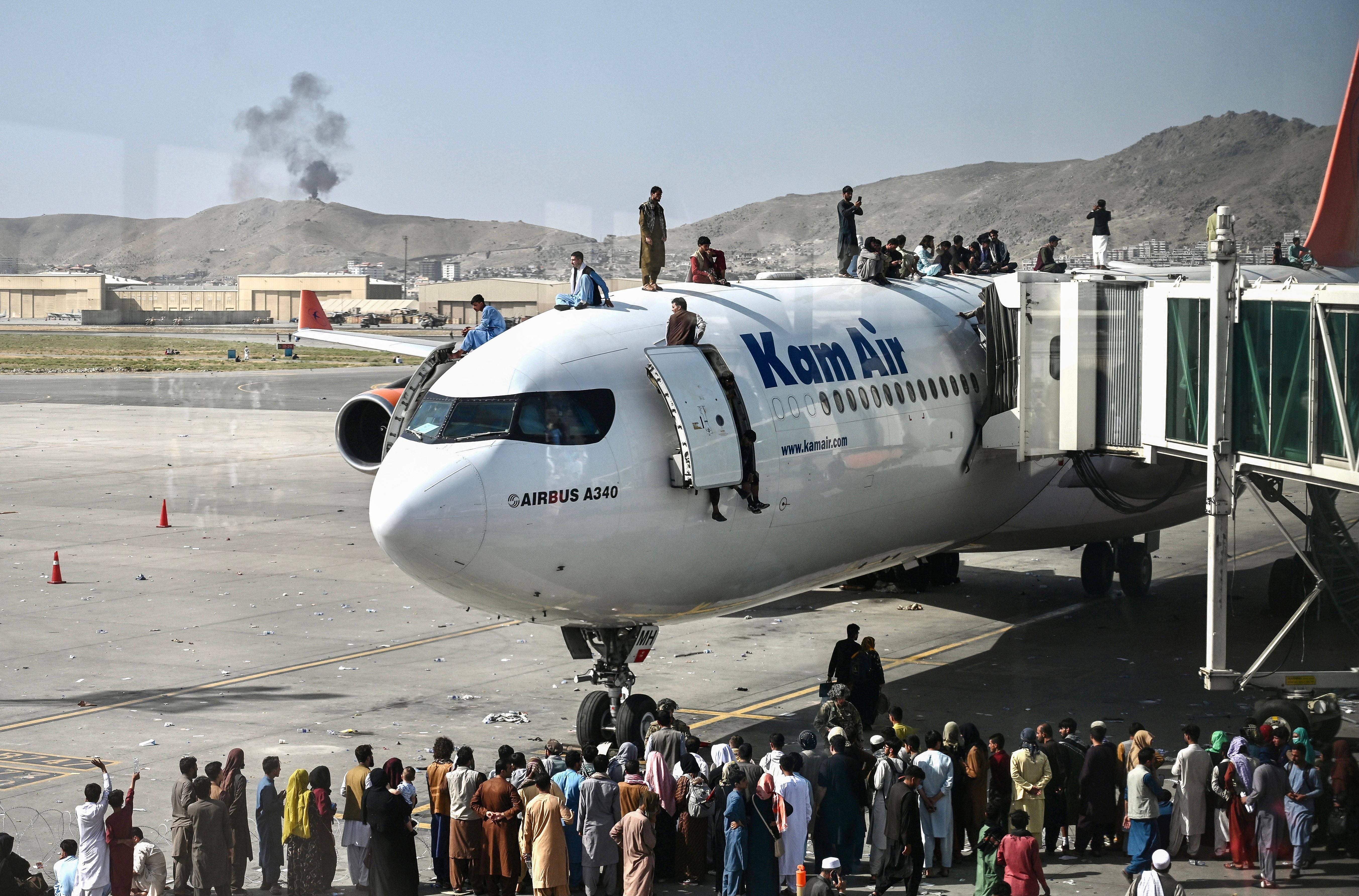 Afghan people climb on top of plan during 2021 evacuation