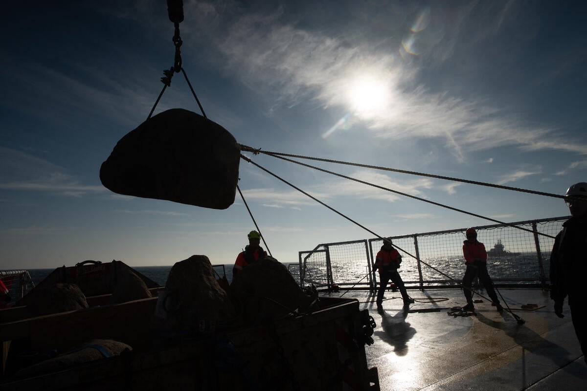 Greenpeace crew heaving boulders into the sea to stop bottom trawling in an off-shore marine protected area (Suzanne Plunkett/Greenpeace/PA)