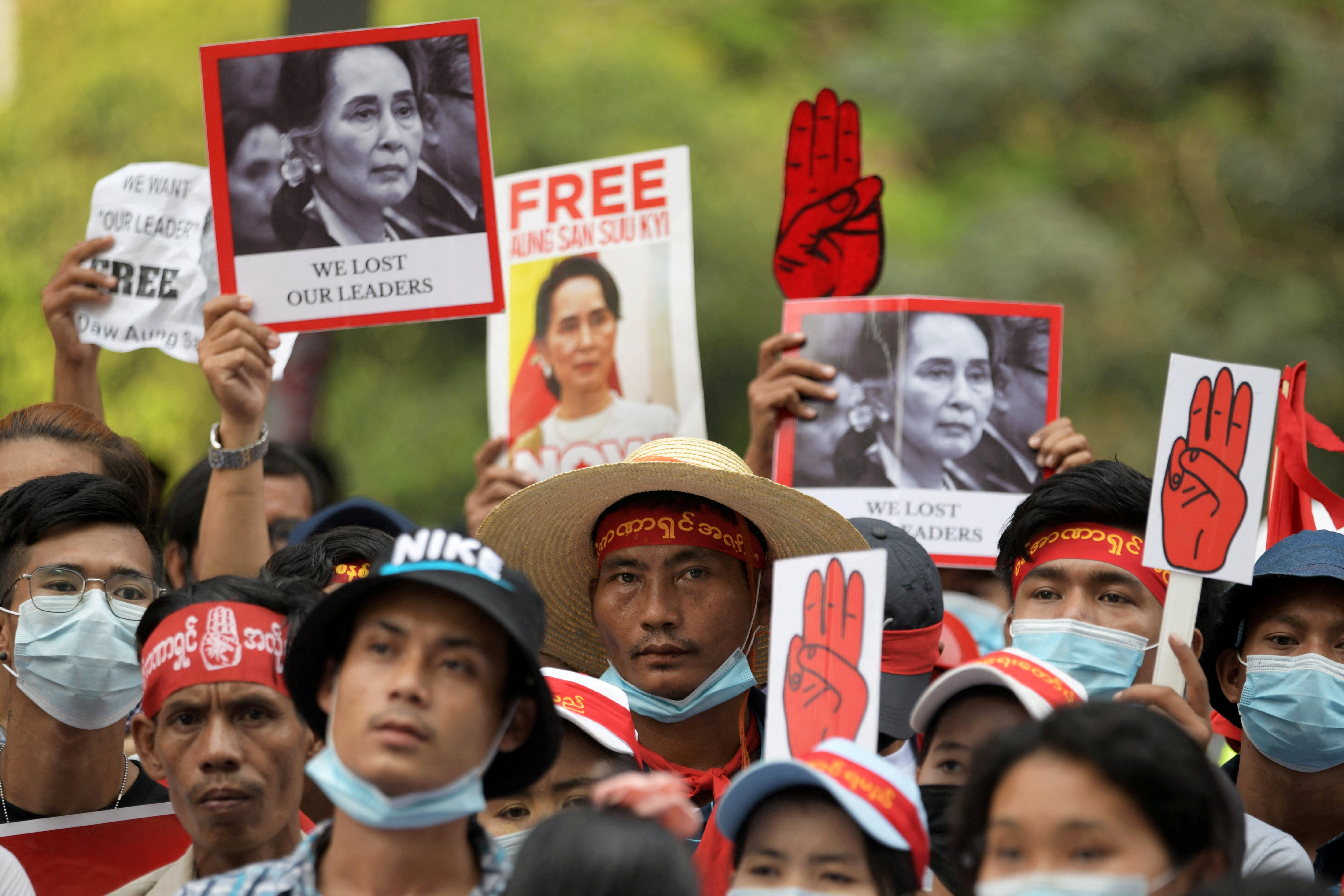 Demonstrators hold placards with pictures of Aung San Suu Kyi as they protest against the military coup in Yangon