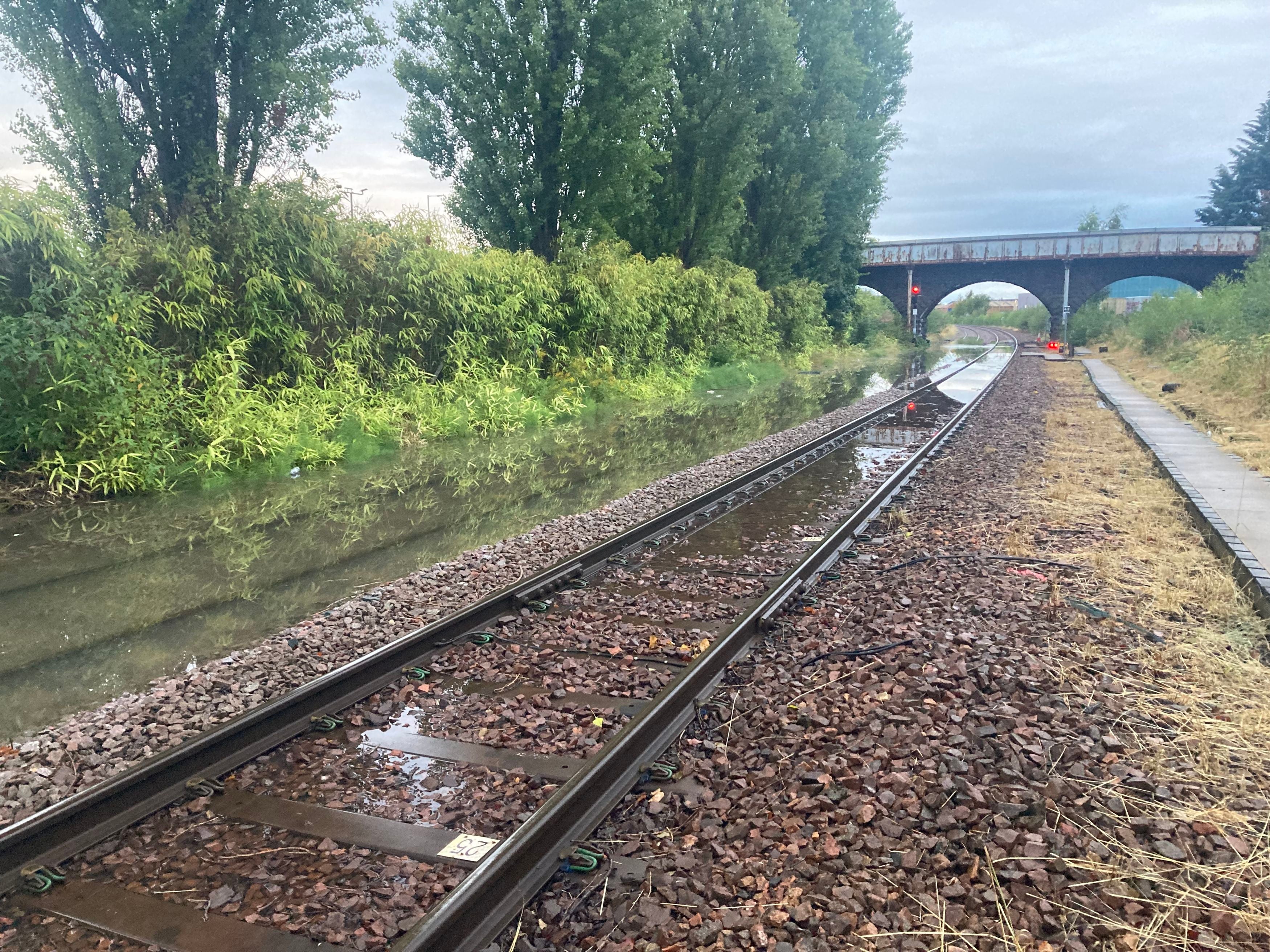 Rail line submerged by flooding at Perth station (left)