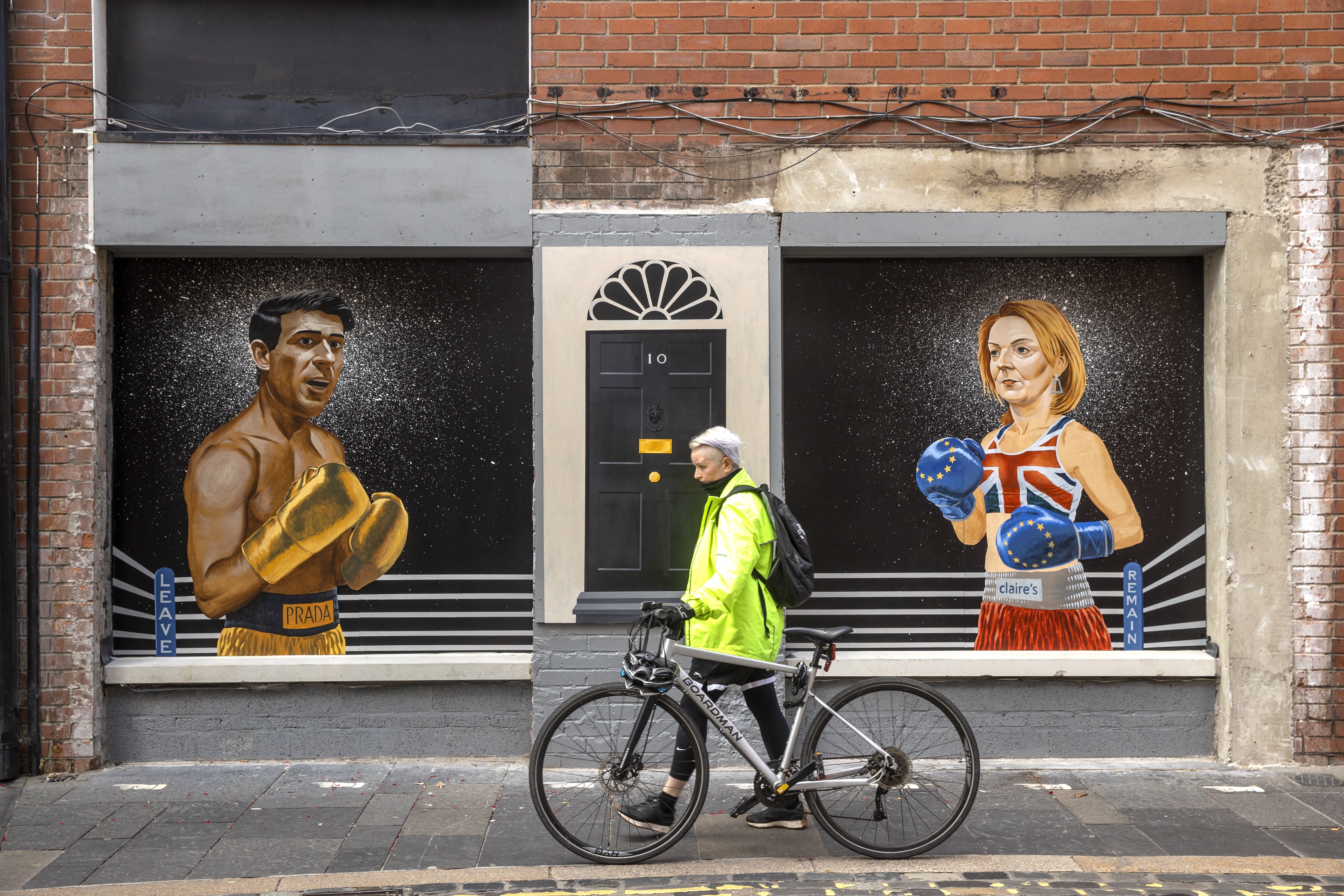 A women walks past a mural on Hill Street in Belfast by Ciaran Gallagher Art (PA)