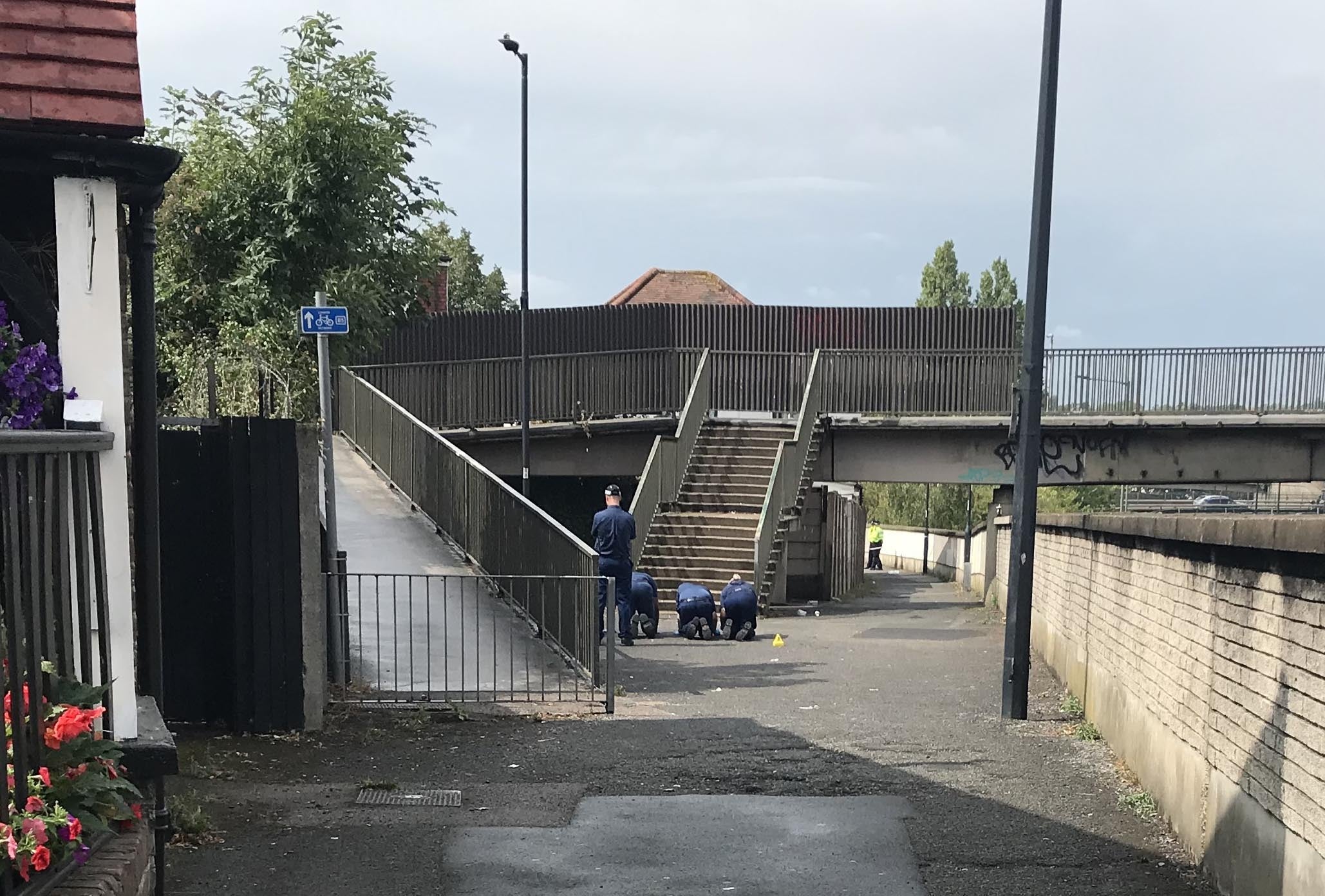 Police inspect the ground on the footpath between Balnacraig Avenue and Ballogie Avenue following a shooting on Monday in Dog Lane in Brent, north-west London (Andrew Quinn/PA)