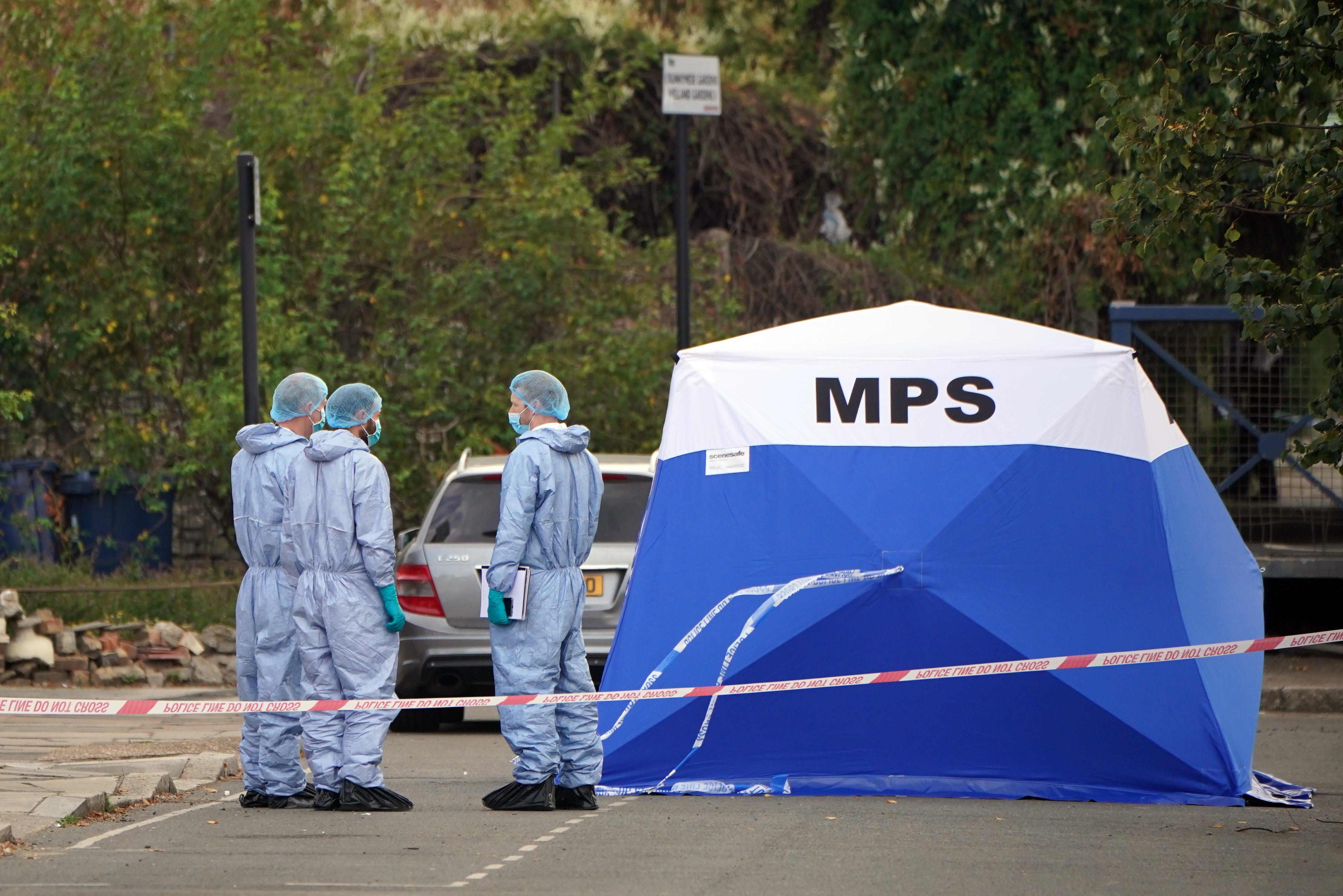 Forensic officers at the scene near to Cayton Road, Greenford, in west London, where an elderly man who had been riding a mobility scooter was stabbed to death (Jonathan Brady/PA)