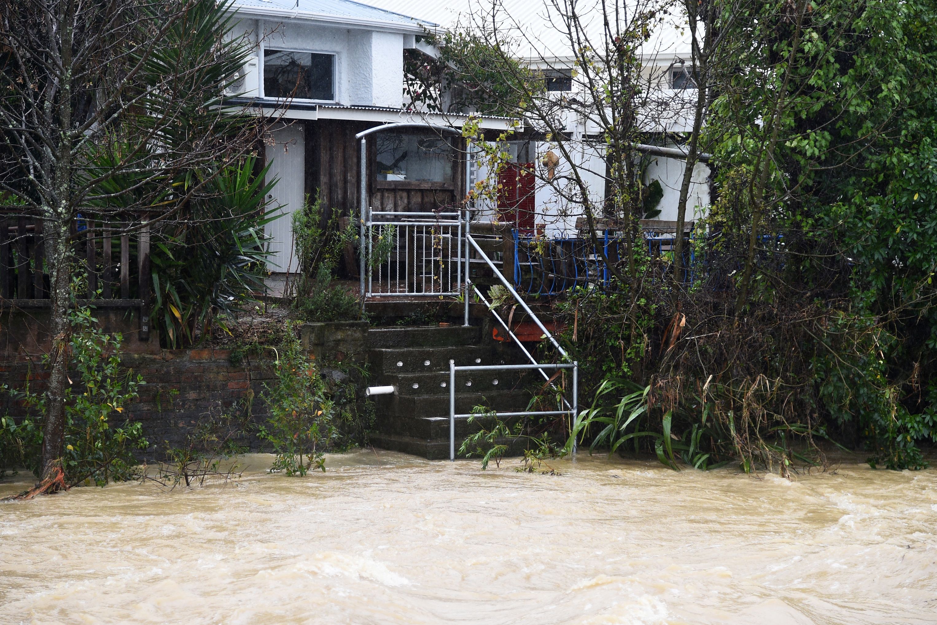 Water from the Maitai river is seen leading up to stairs of a property