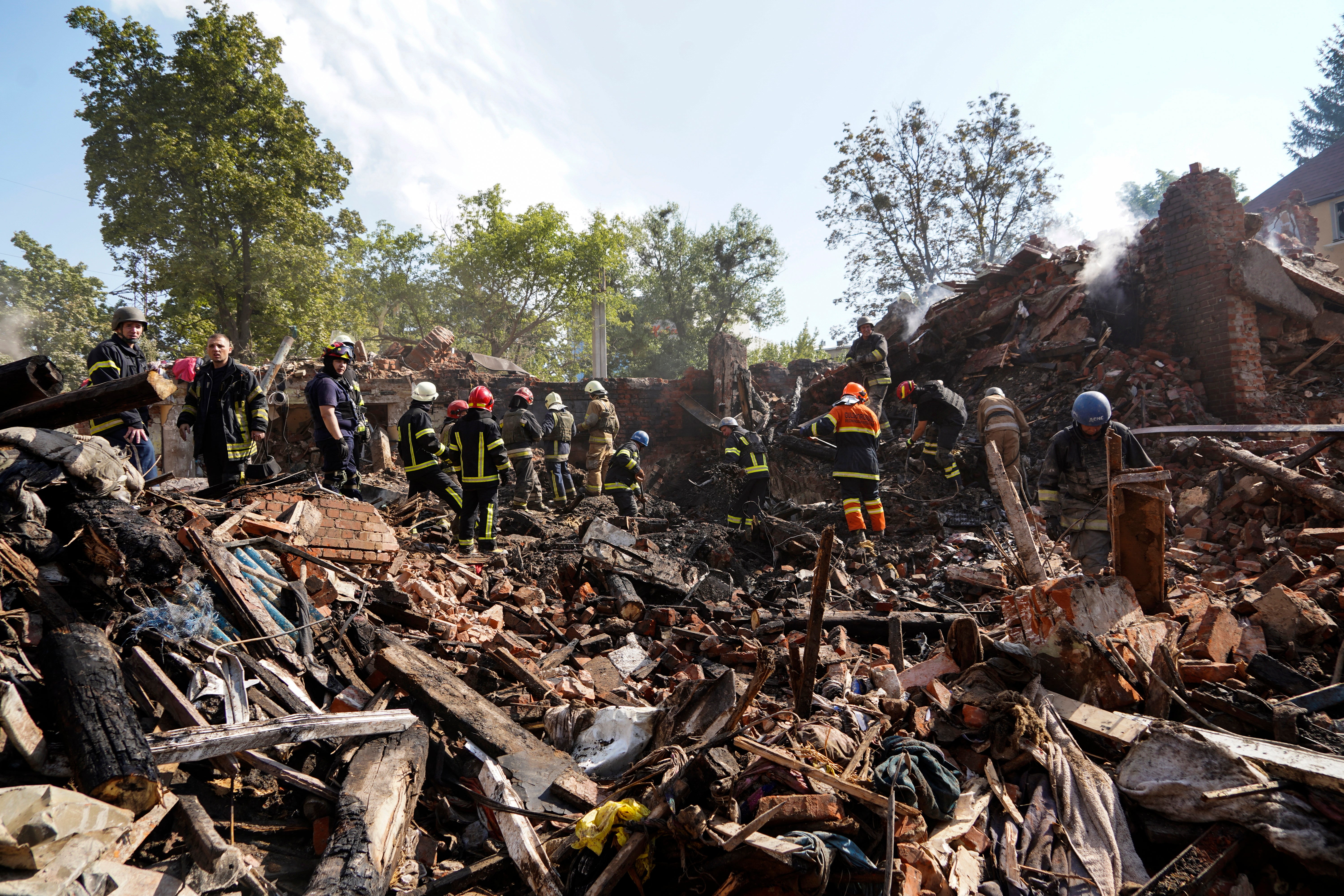 Ukrainian rescuers search the debris of the building hit in Saltivka