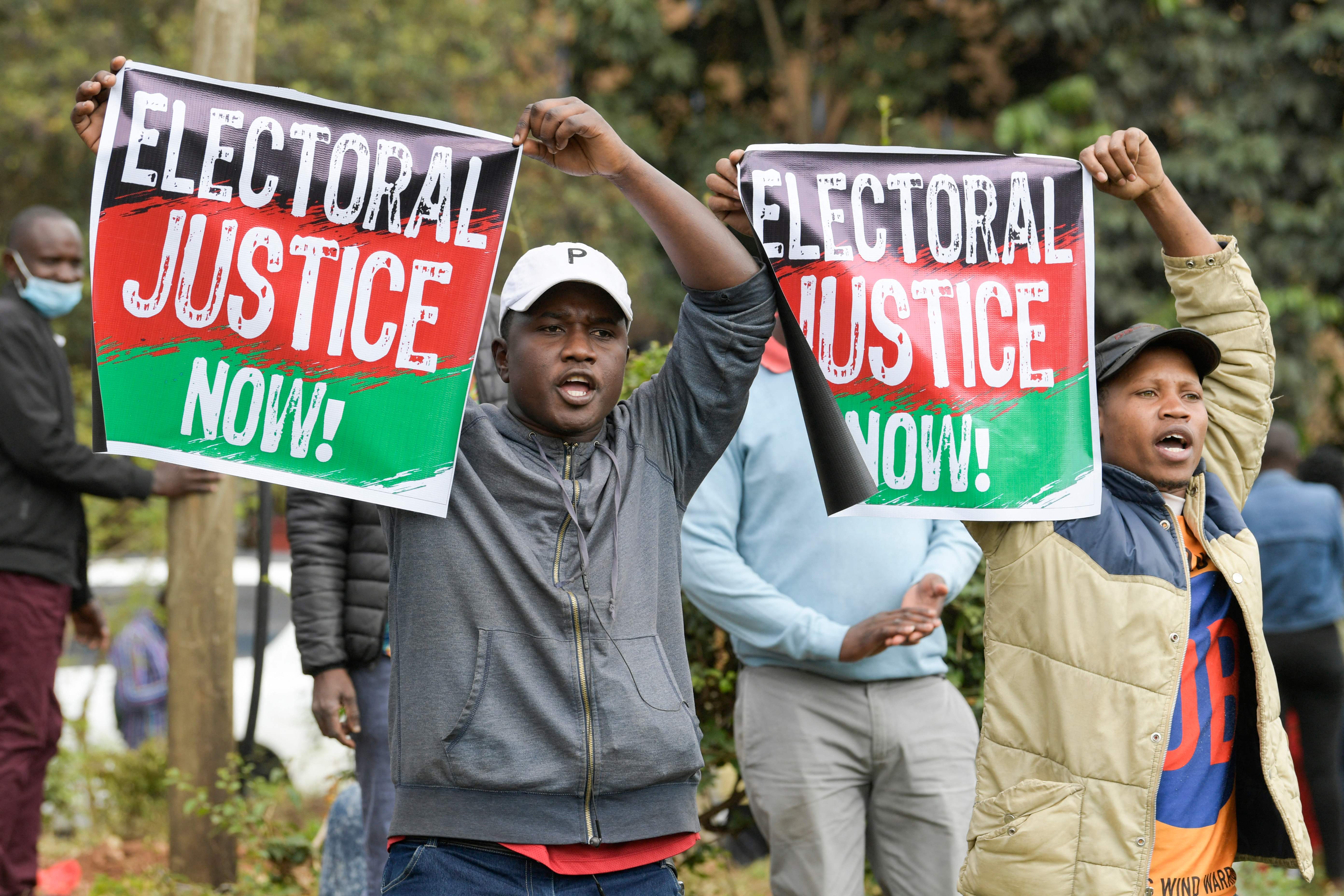 Supporters of Raila Odinga sing as they gather outside the Milimani High Court in Nairobi