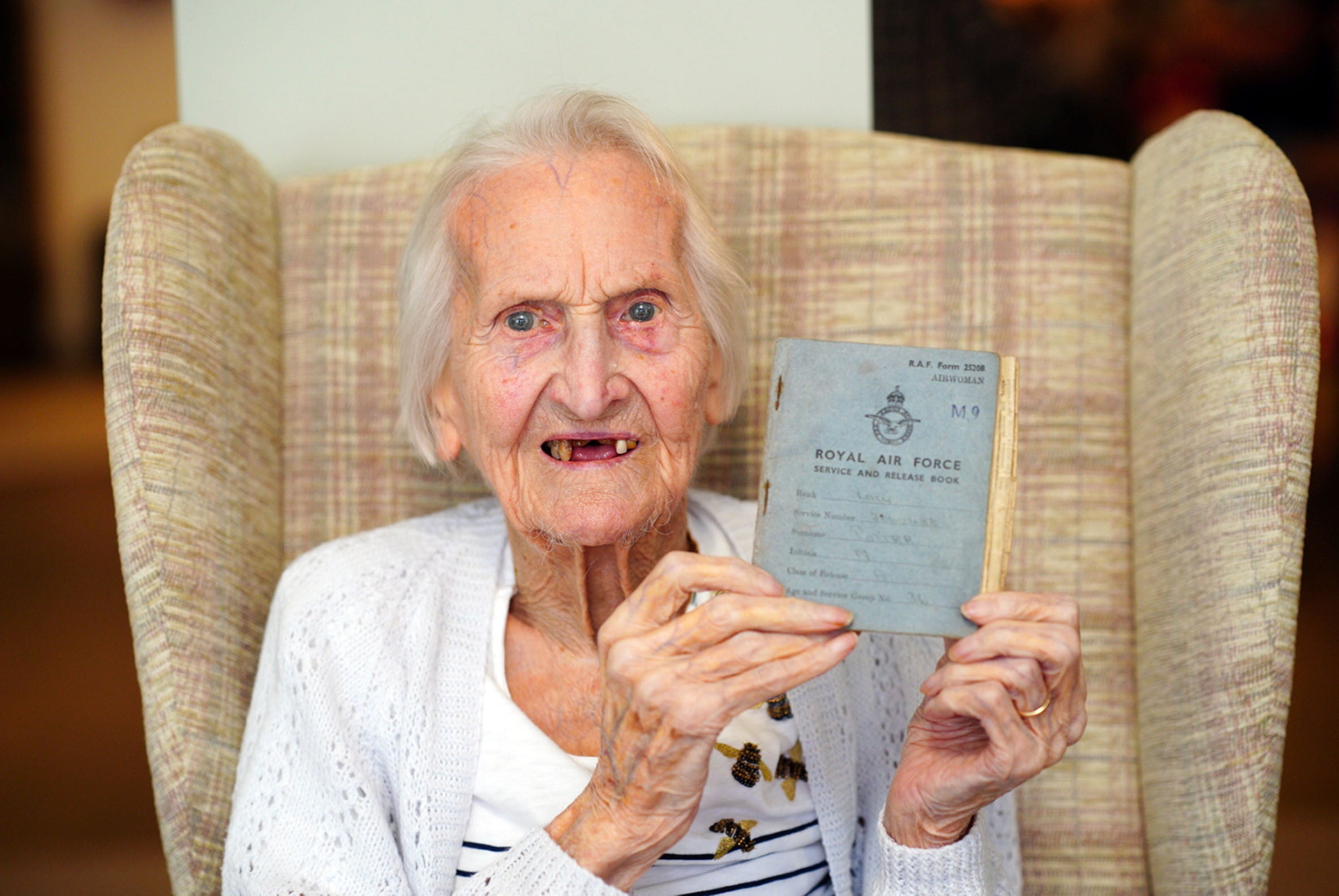 99-year-old WAAF veteran, Mrs Margaret ‘Peggy’ Terry, holds her RAF service record document (PA)