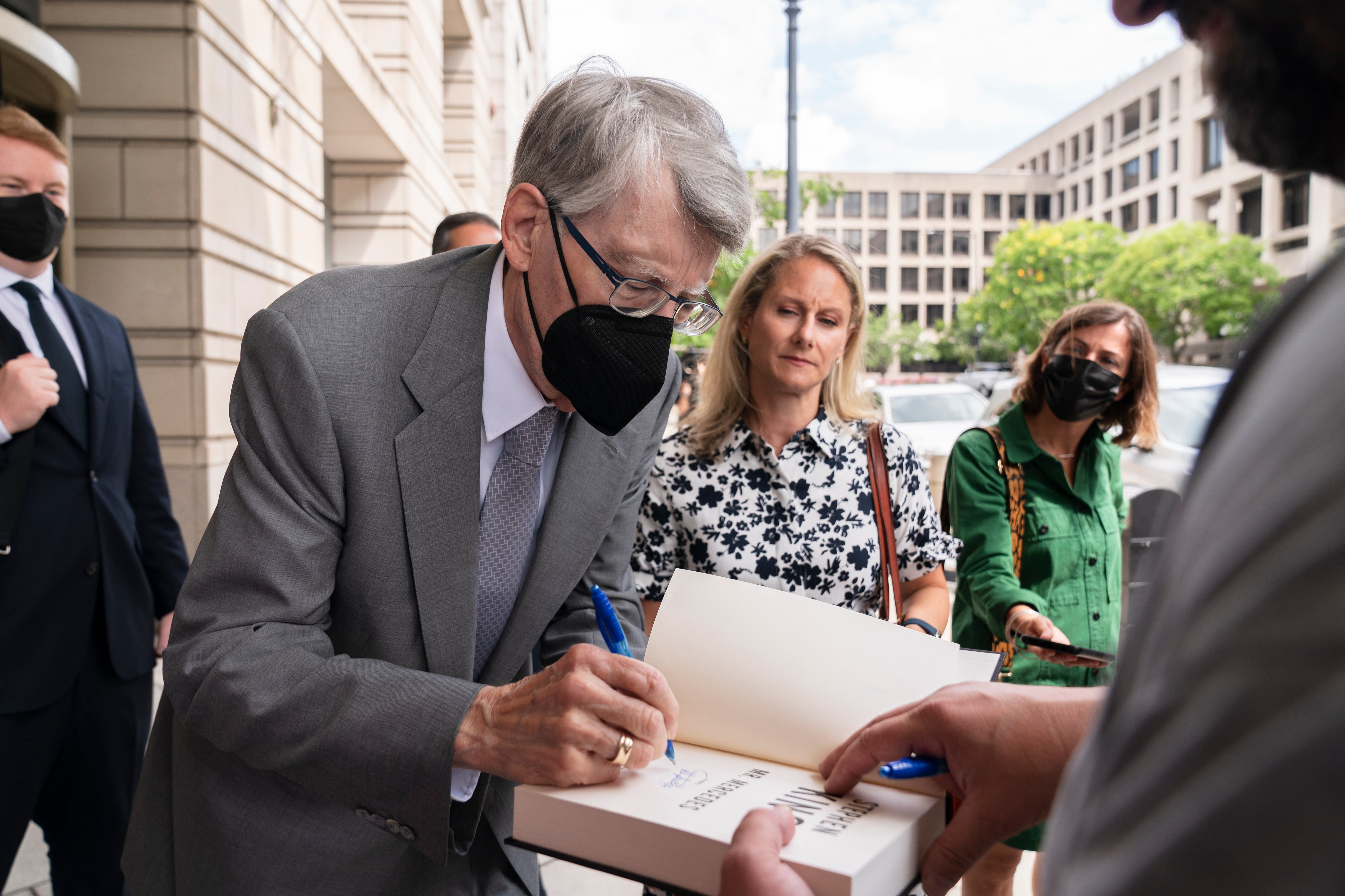 Stephen King signs autographs as he leaves court after testifying against the proposed merger of Penguin Random House and Simon & Schuster