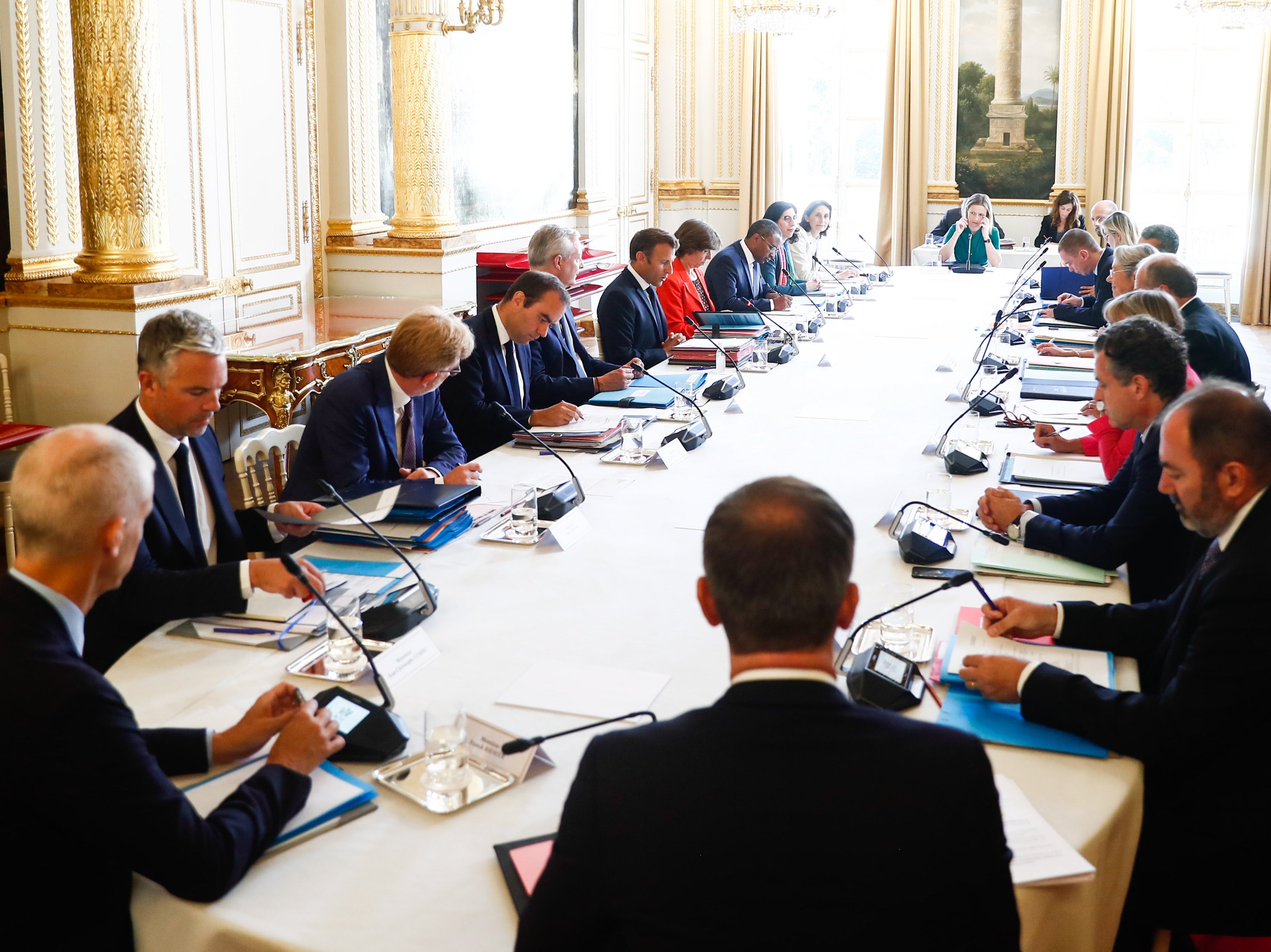 Emmanuel Macron (C-L) attends the cabinet meeting with ministers at the Elysee Palace