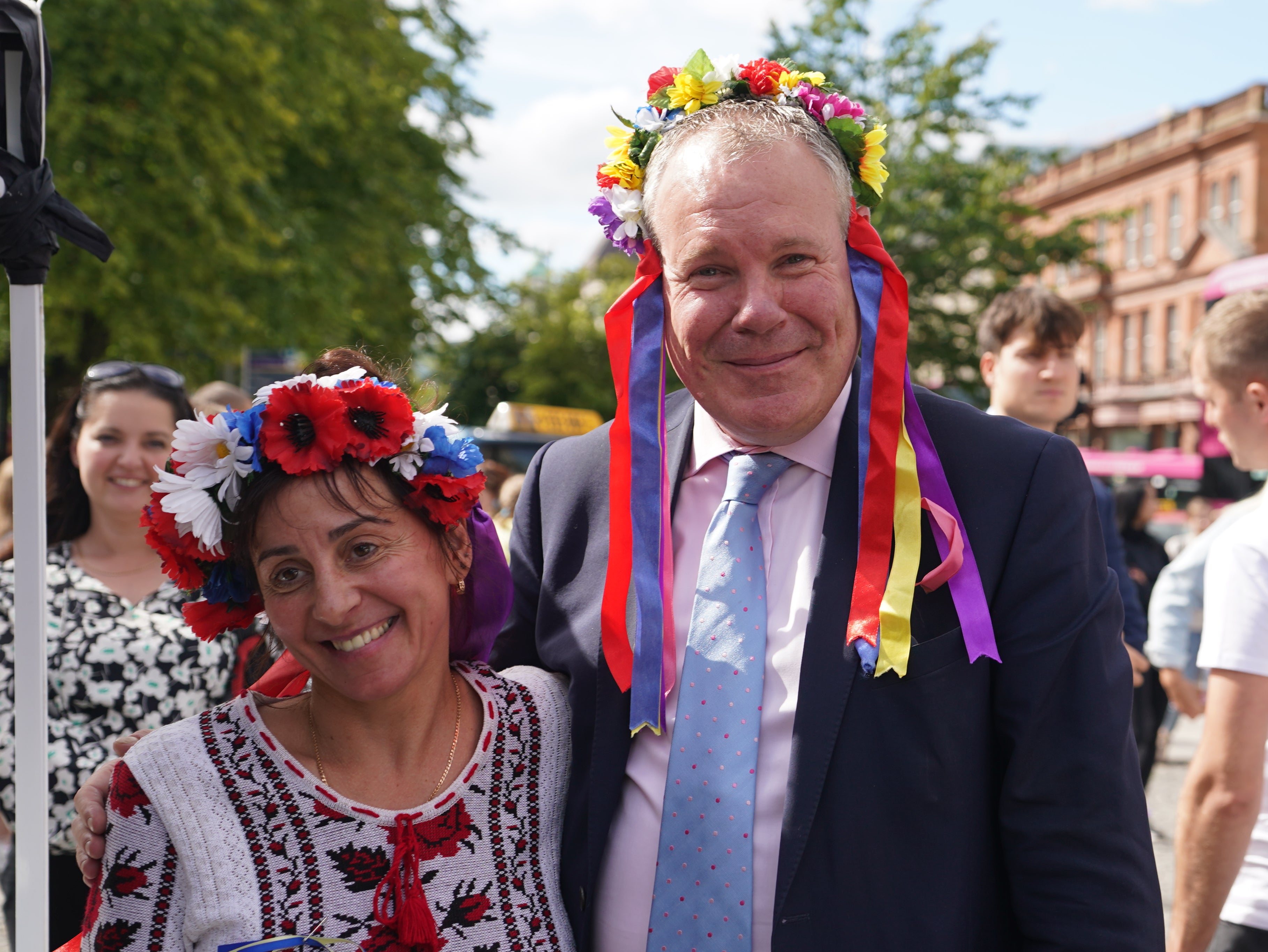 Conor Burns (left), Minister of State for Northern Ireland speaks with Marina Furey from Znamjanka, as he joins Ukrainians celebrating Ukraine independence Day, outside Belfast City Hall (Niall Carson/PA)