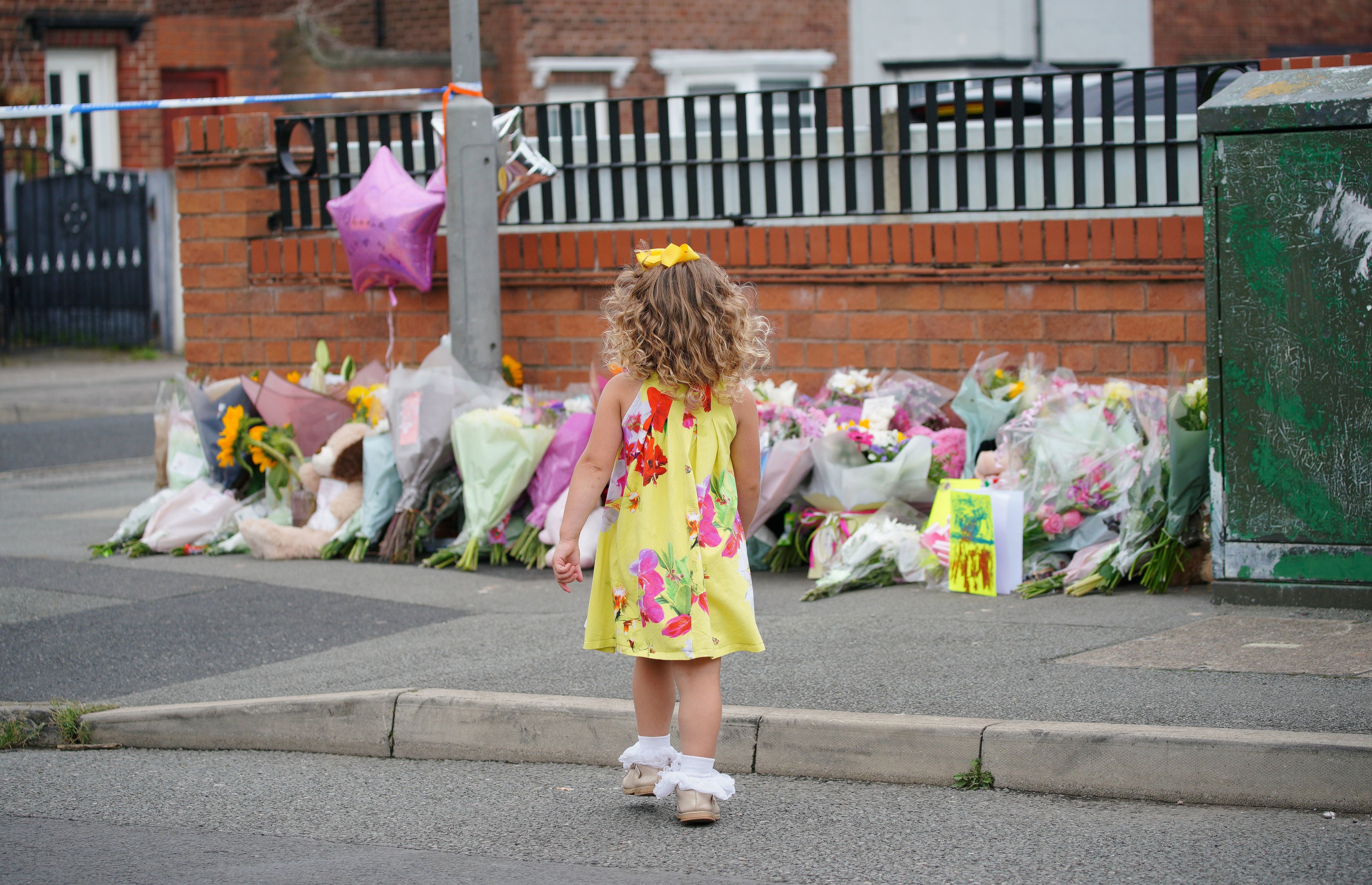 A girl in the street outside the house where Olivia was killed