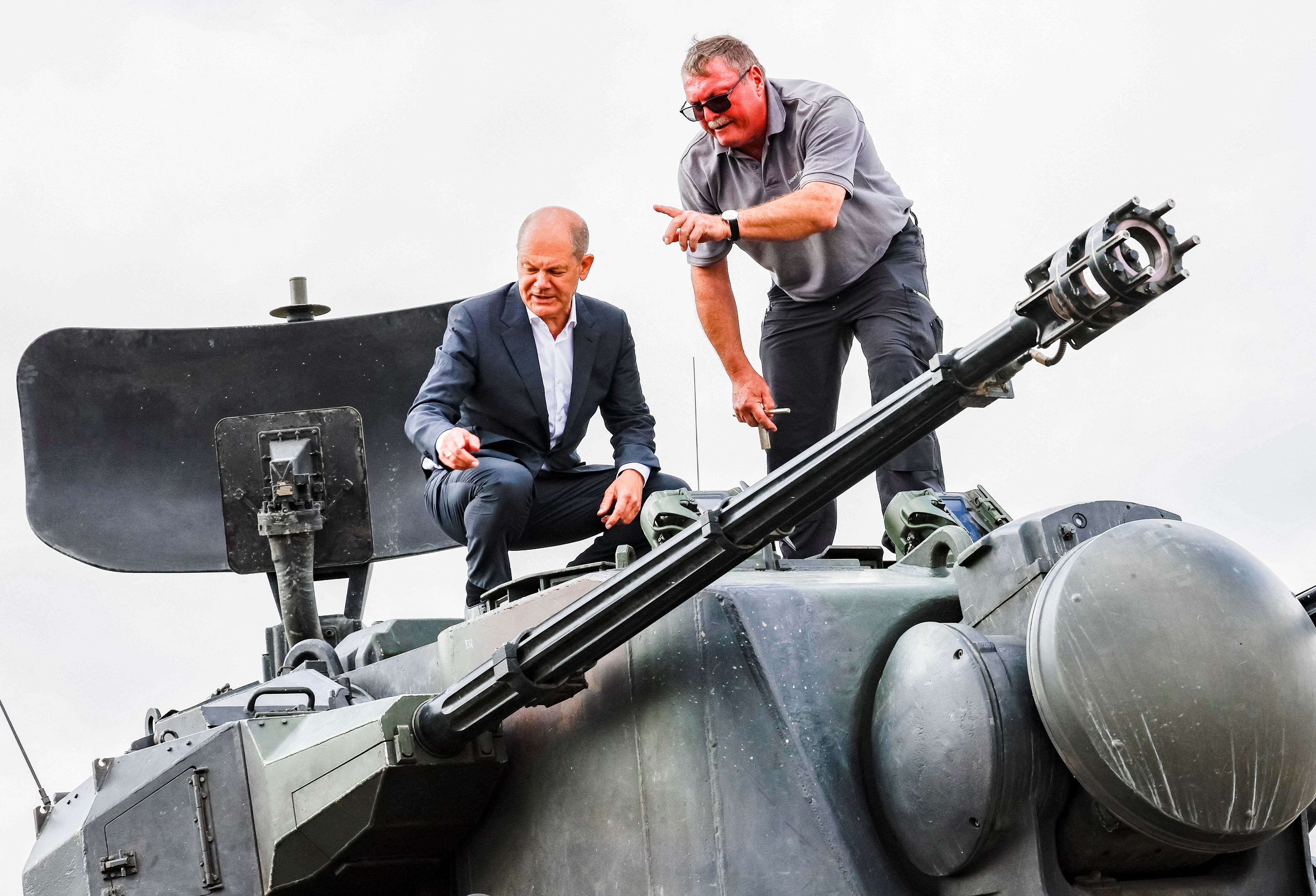 German chancellor Olaf Scholz inspects an anti-aircraft gun.