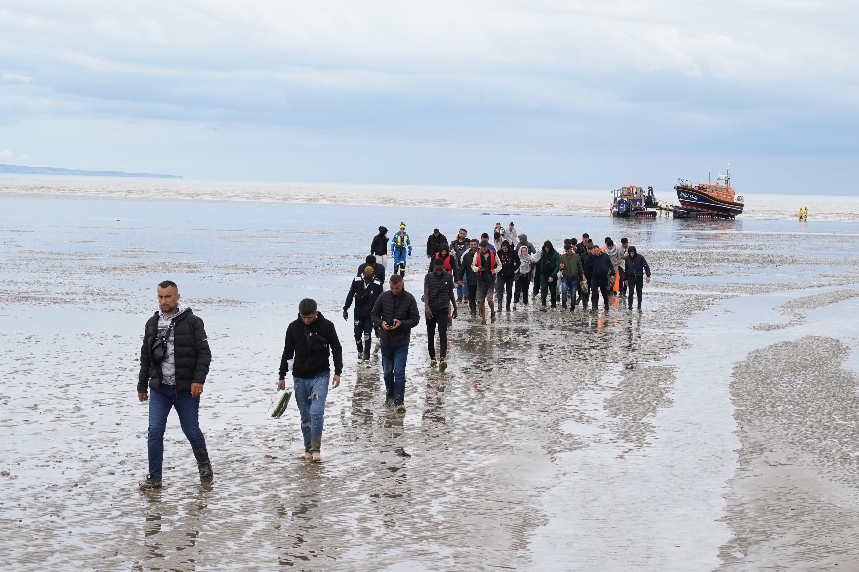 A group of people, thought to be migrants, walk ashore in Dover, Kent, following a small boat incident in the Channel. Picture date: Thursday August 25, 2022. (Gareth Fuller/PA)