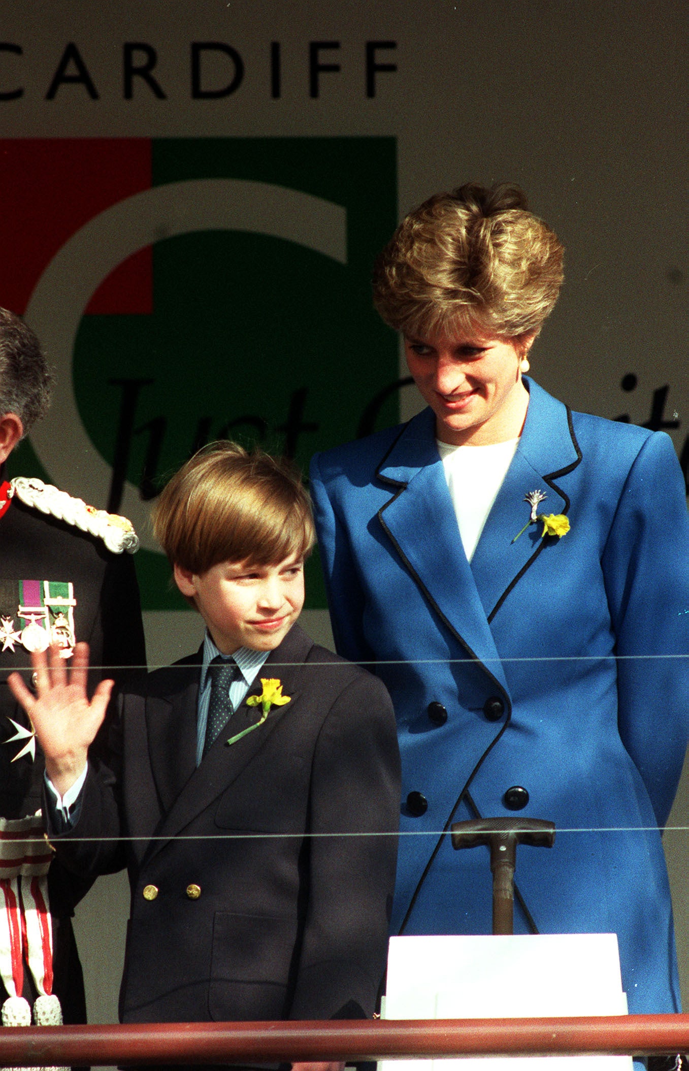 Prince William waves to the crowds as his mother, the Princess of Wales, looks on appprovingly during a visit to St. David’s Hall, Cardiff in March 1991