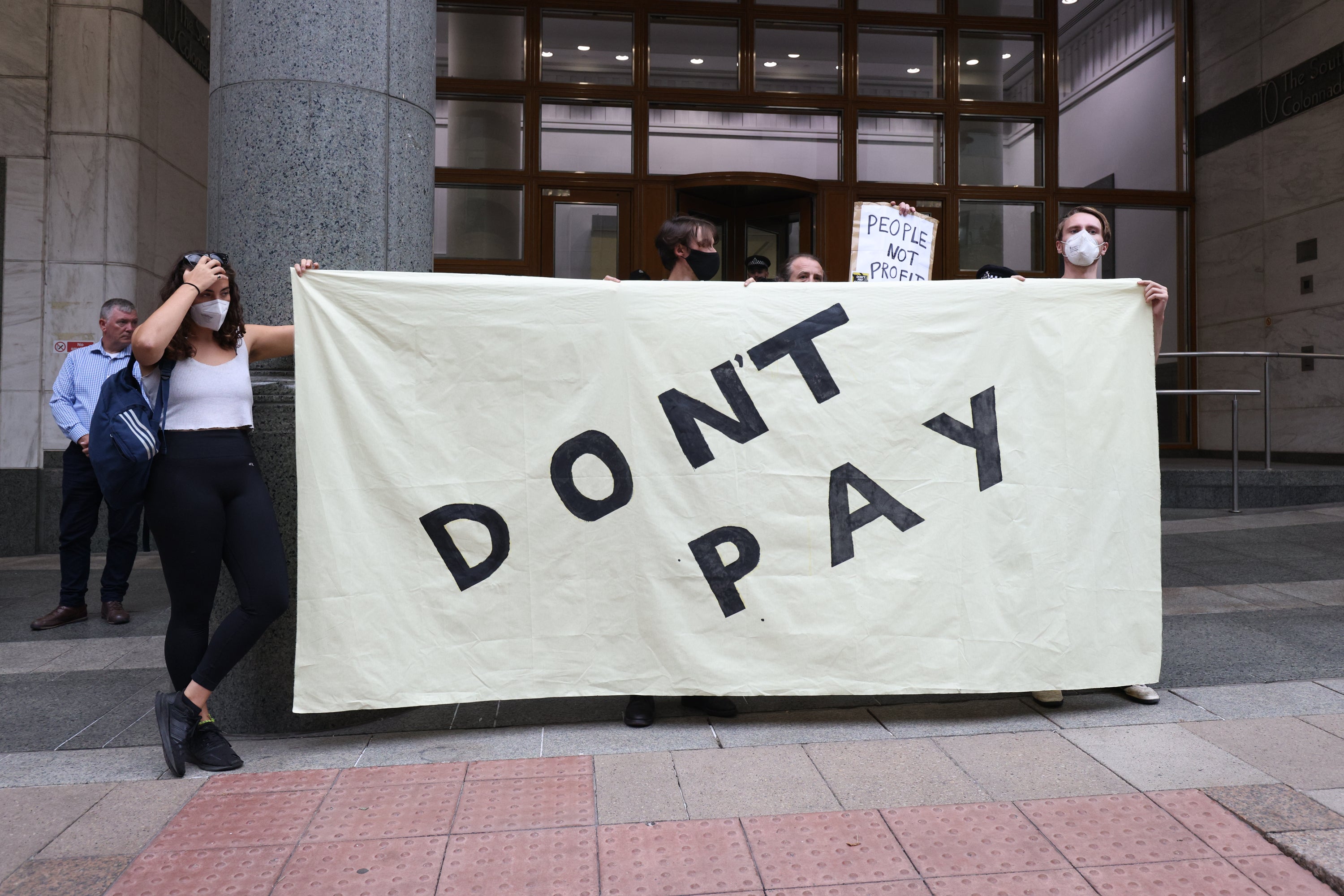 A woman holds a banner during a protest outside the Ofgem HQ