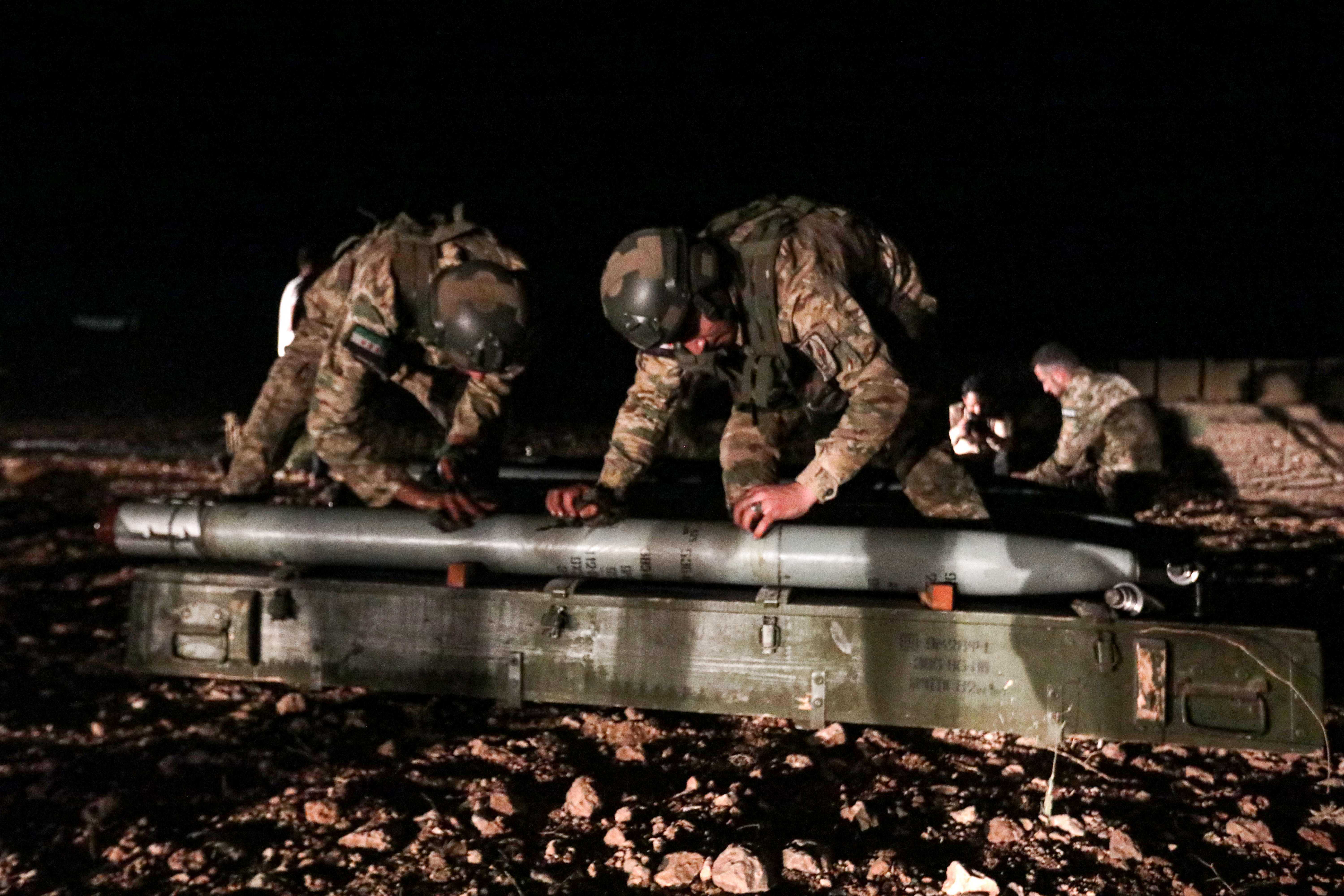 Turkish-backed Syrian fighters prepare to load a long-range grad rocket to be fired