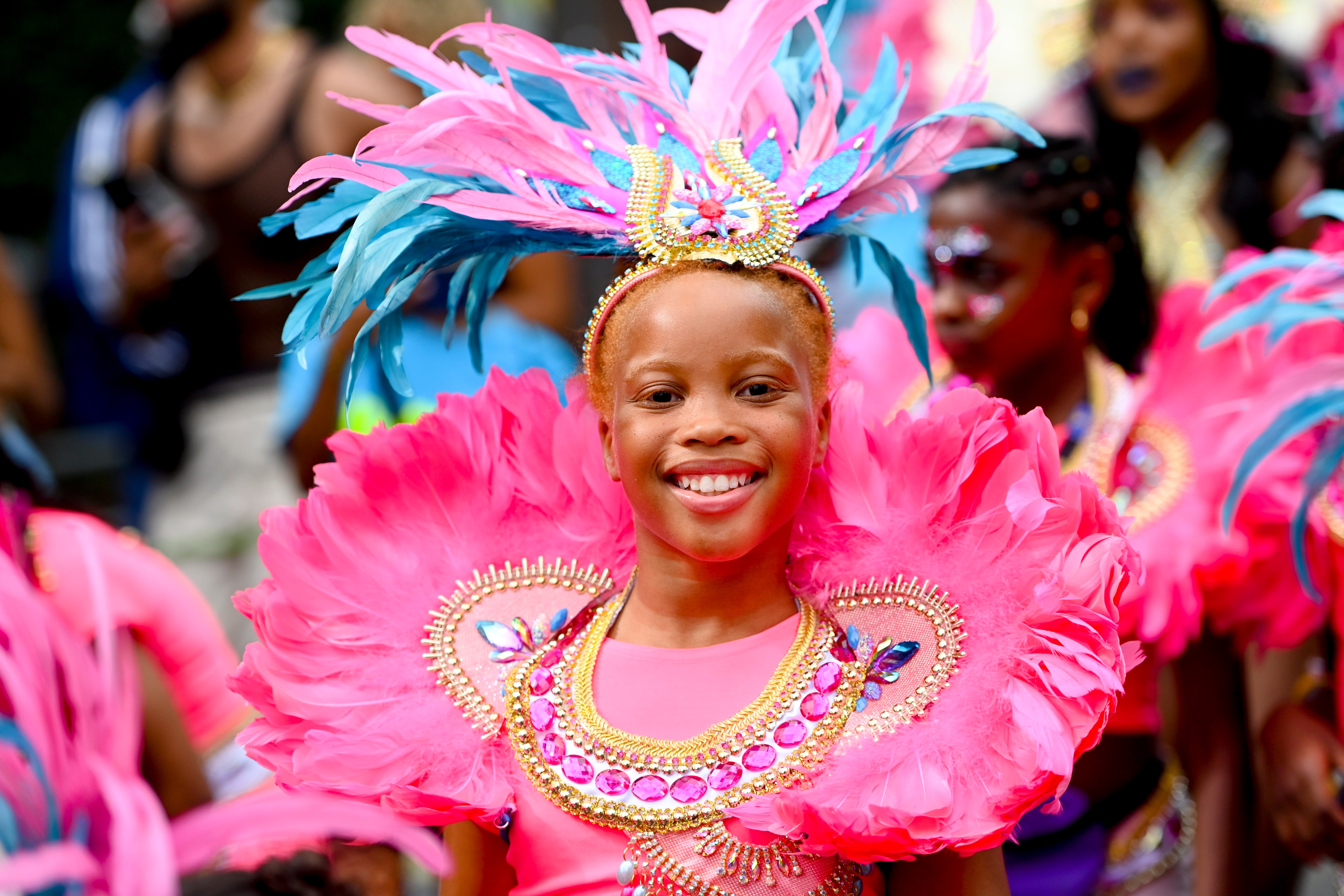 Youths in colourful costumes proceed down Ladbroke Grove