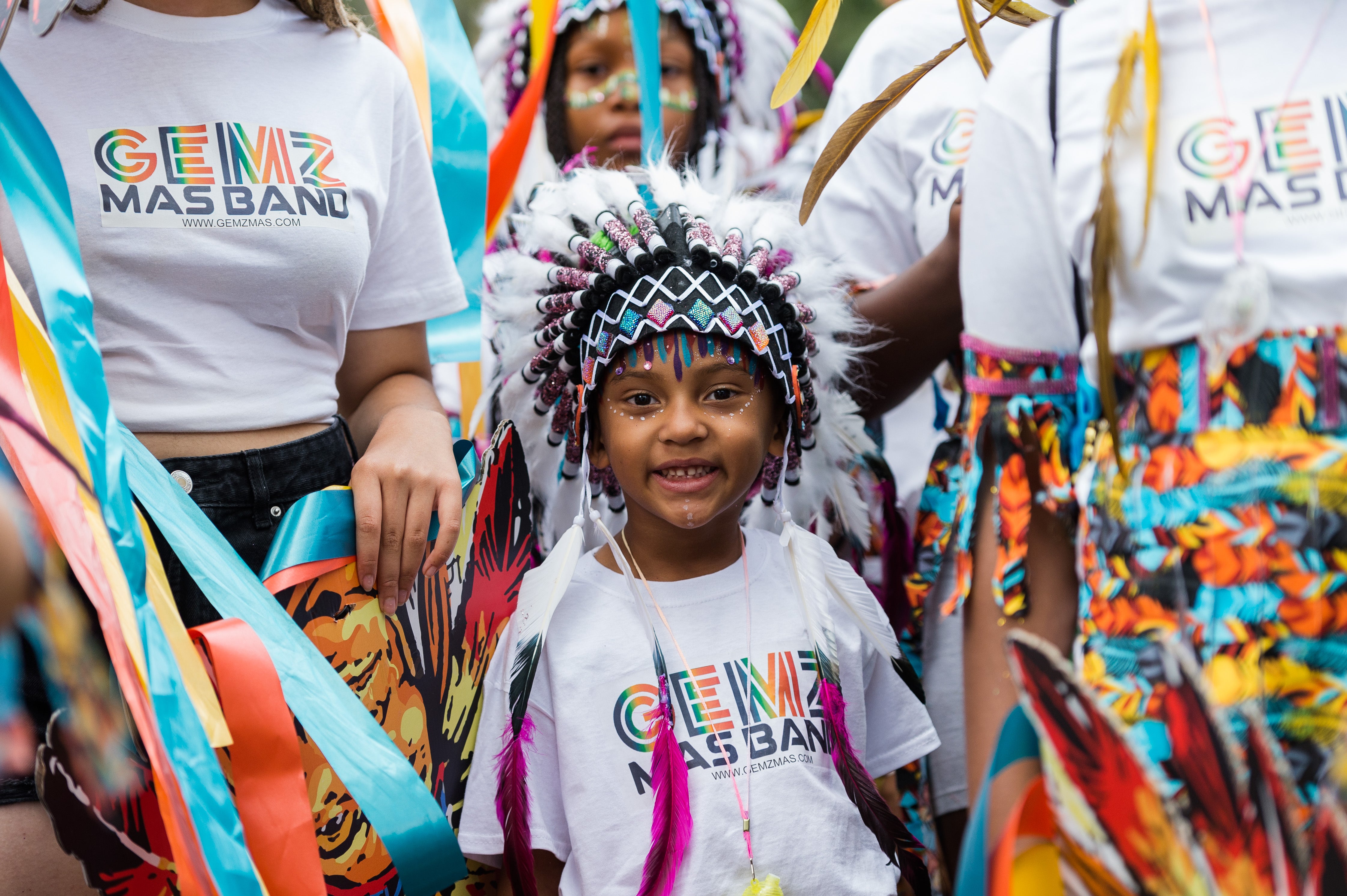 A young performer in a colourful costume takes part in Children's Parade