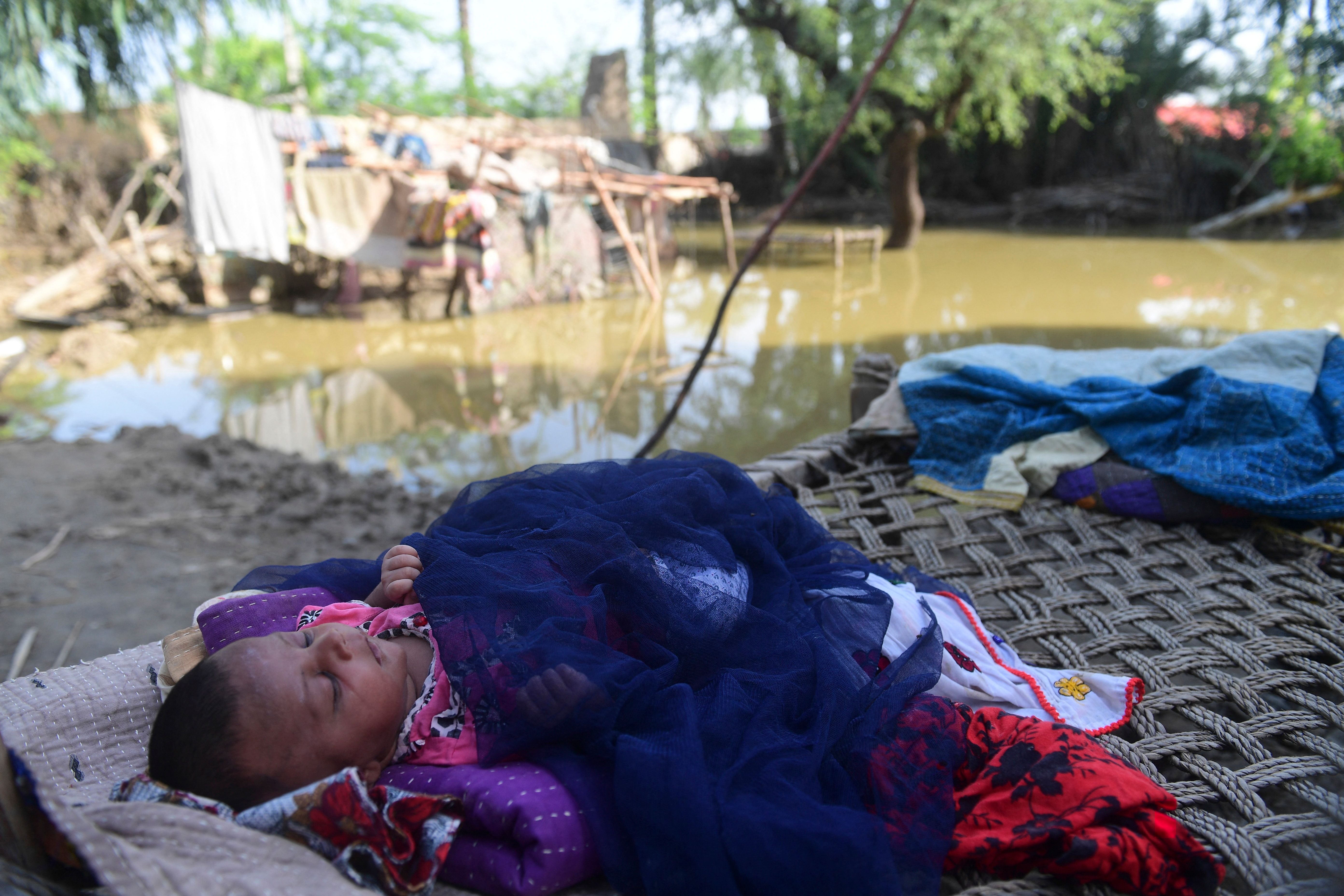 Newborn baby Yasmeem sleeps on a cot at her flood-damaged house on the outskirts of Sukkur, Sindh province