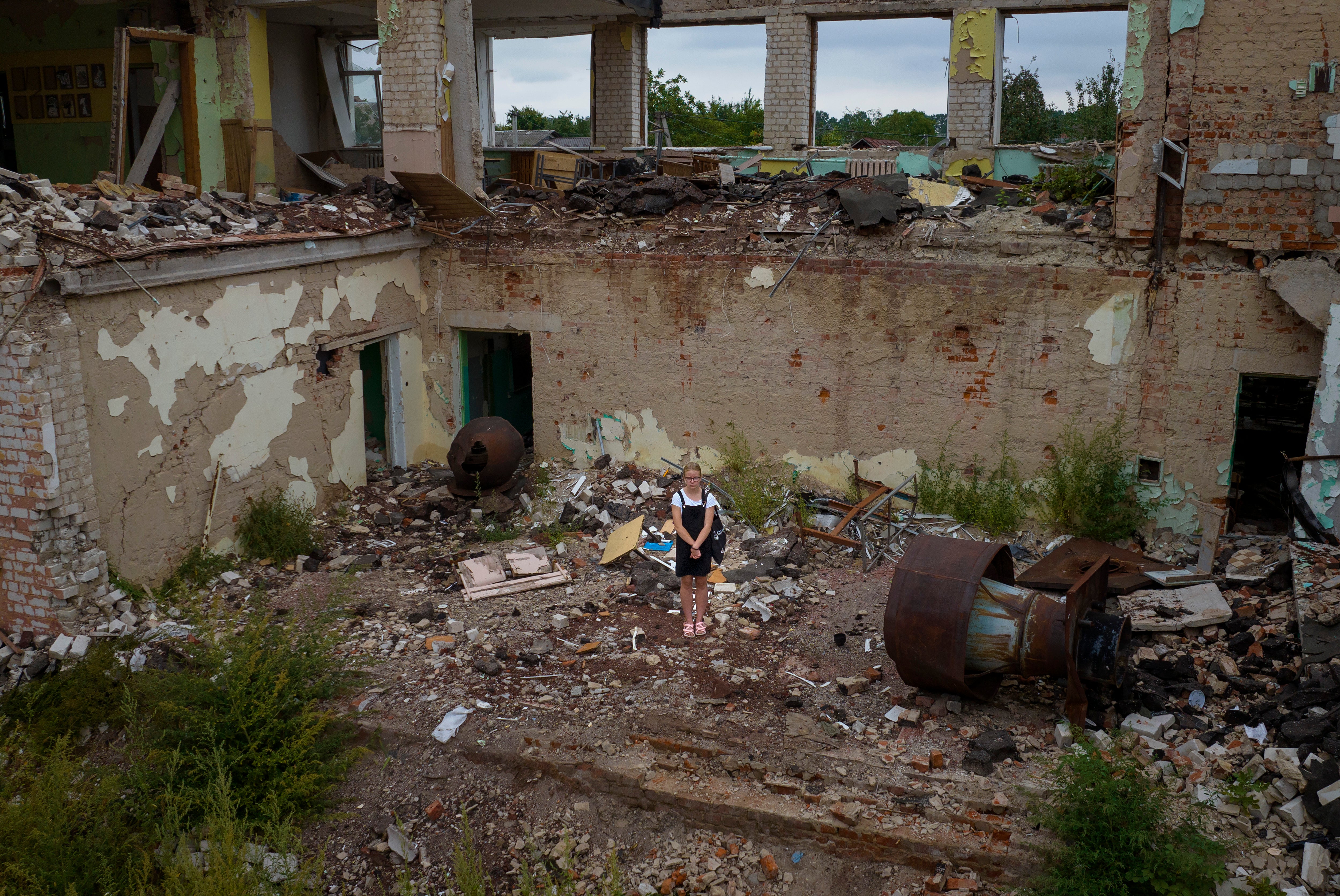 Anastasia Avramenko, 13, stands in the rubble of her former classroom, in the same position where her desk sat before the Chernihiv School #21 was bombed on 3 March in Chernihiv