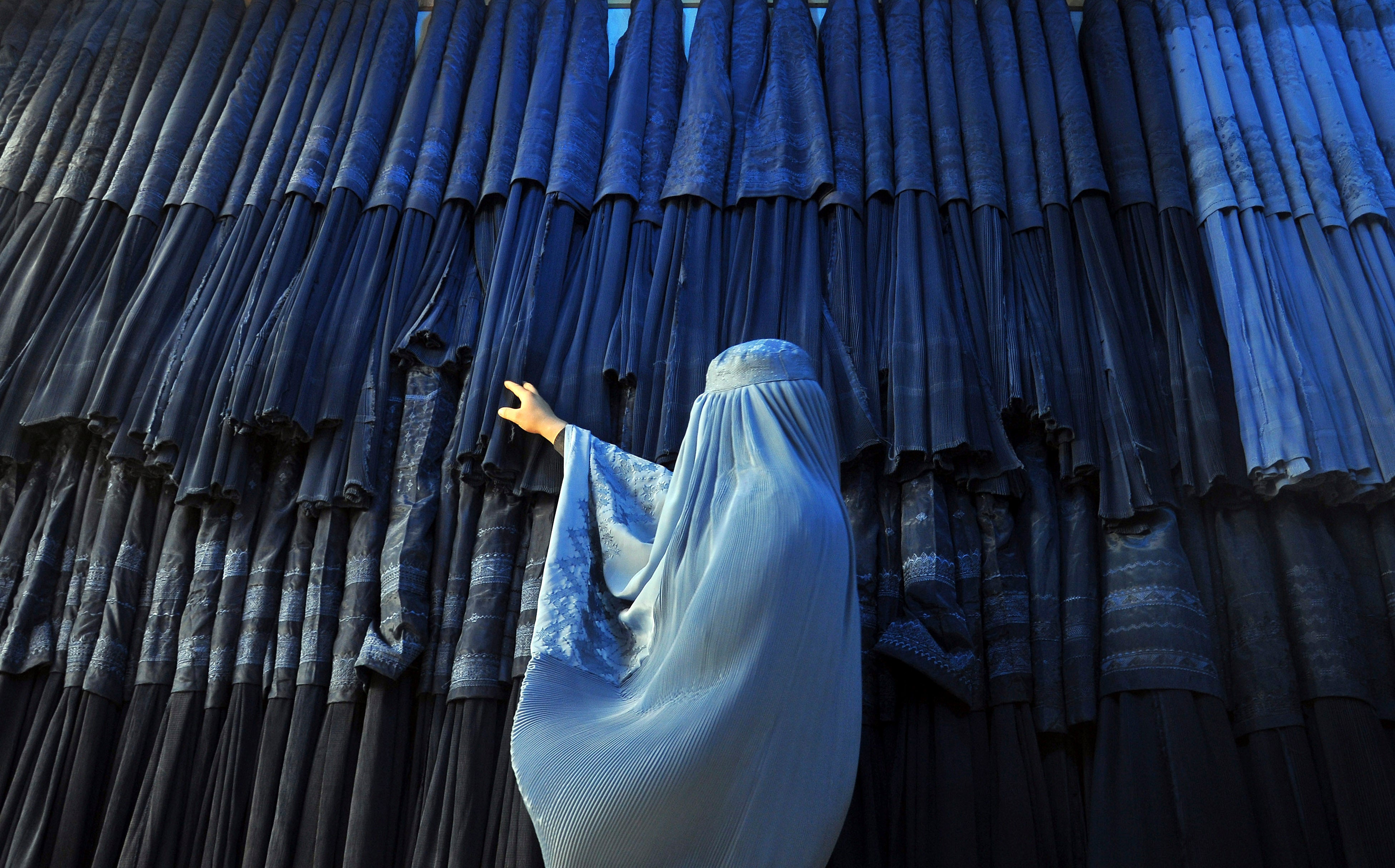 File photo: A woman clad in a burqa looks at other pieces of Afghanistan's traditional, all-encompassing dress at a store in Mazar-i Sharif, north of Kabul, Afghanistan in 2015