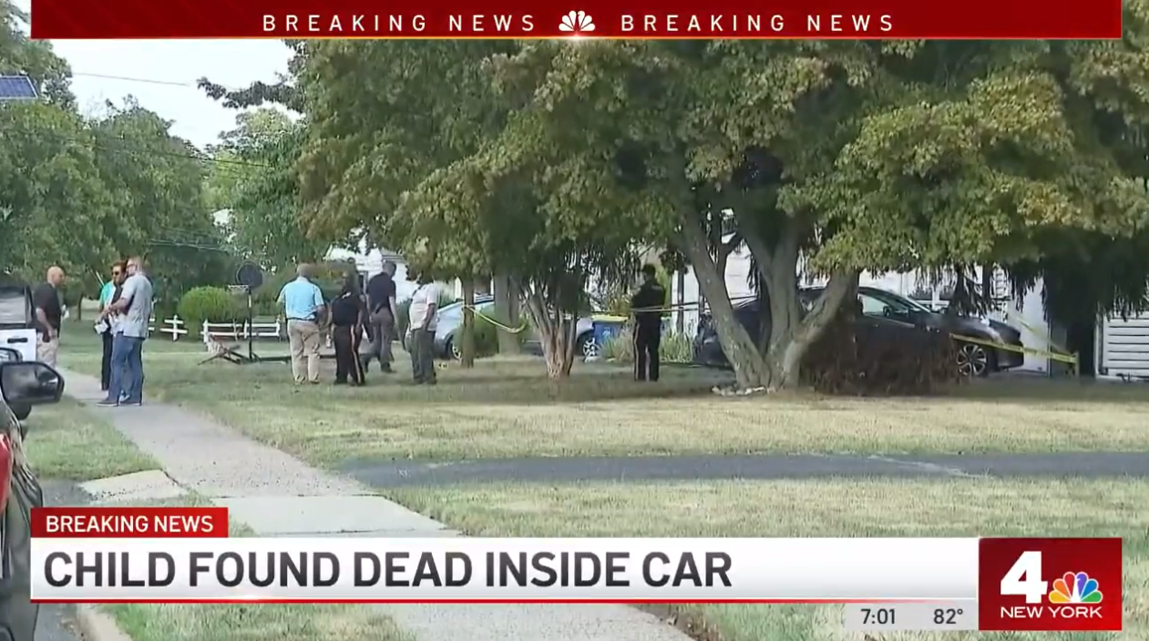 Officers process the scene where a toddler was found dead inside a hot car on Tuesday