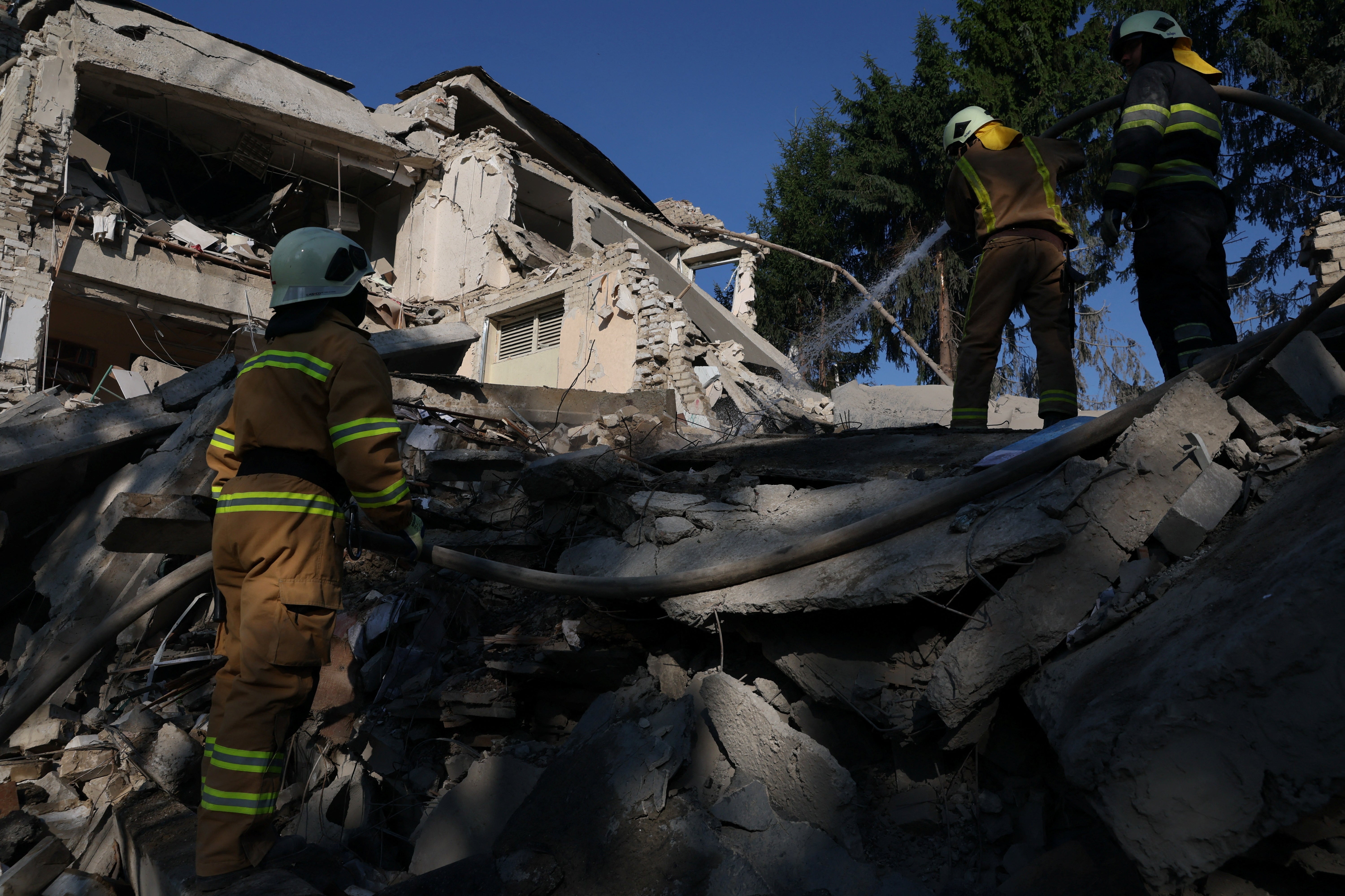 Russia’s war on Ukraine continues to rage – here firefighters finish putting out a blaze after the overnight shelling of a school