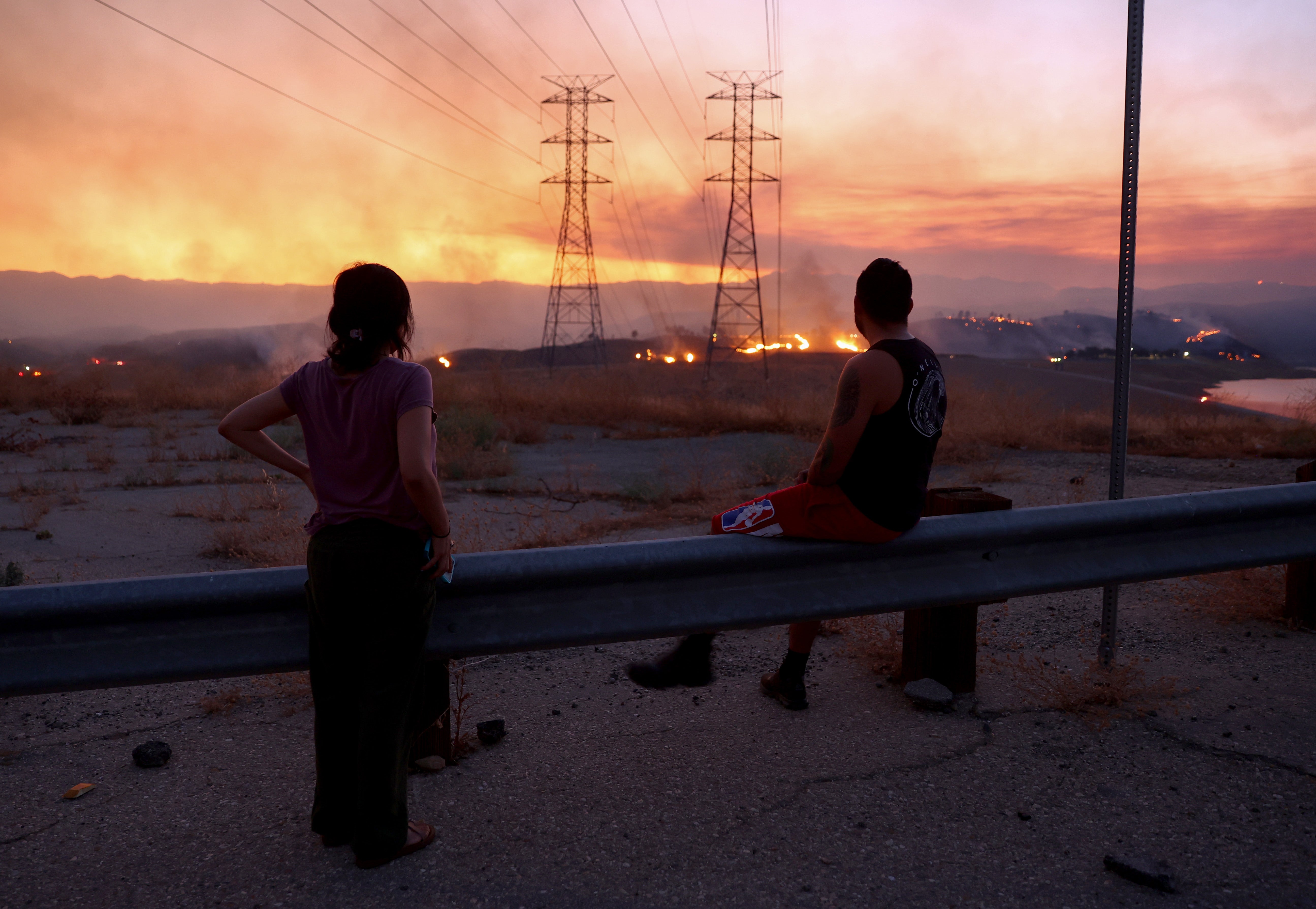 People evacuated from the Route Fire in Los Angeles County in 2023 watch the blaze burn. A massive heatwave in California this week raises concerns of more fires