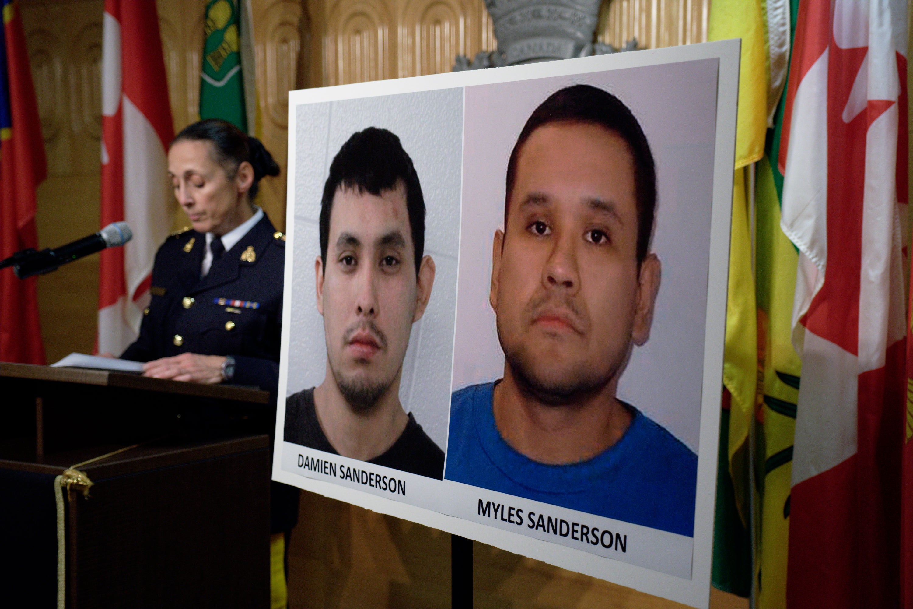 Assistant Commissioner Rhonda Blackmore speaks next to images of Damien Sanderson and Myles Sanderson during a press conference at the Royal Canadian Mounted Police "F" Division headquarters in Regina, Saskatchewan, on Sunday, Sept. 4, 2022