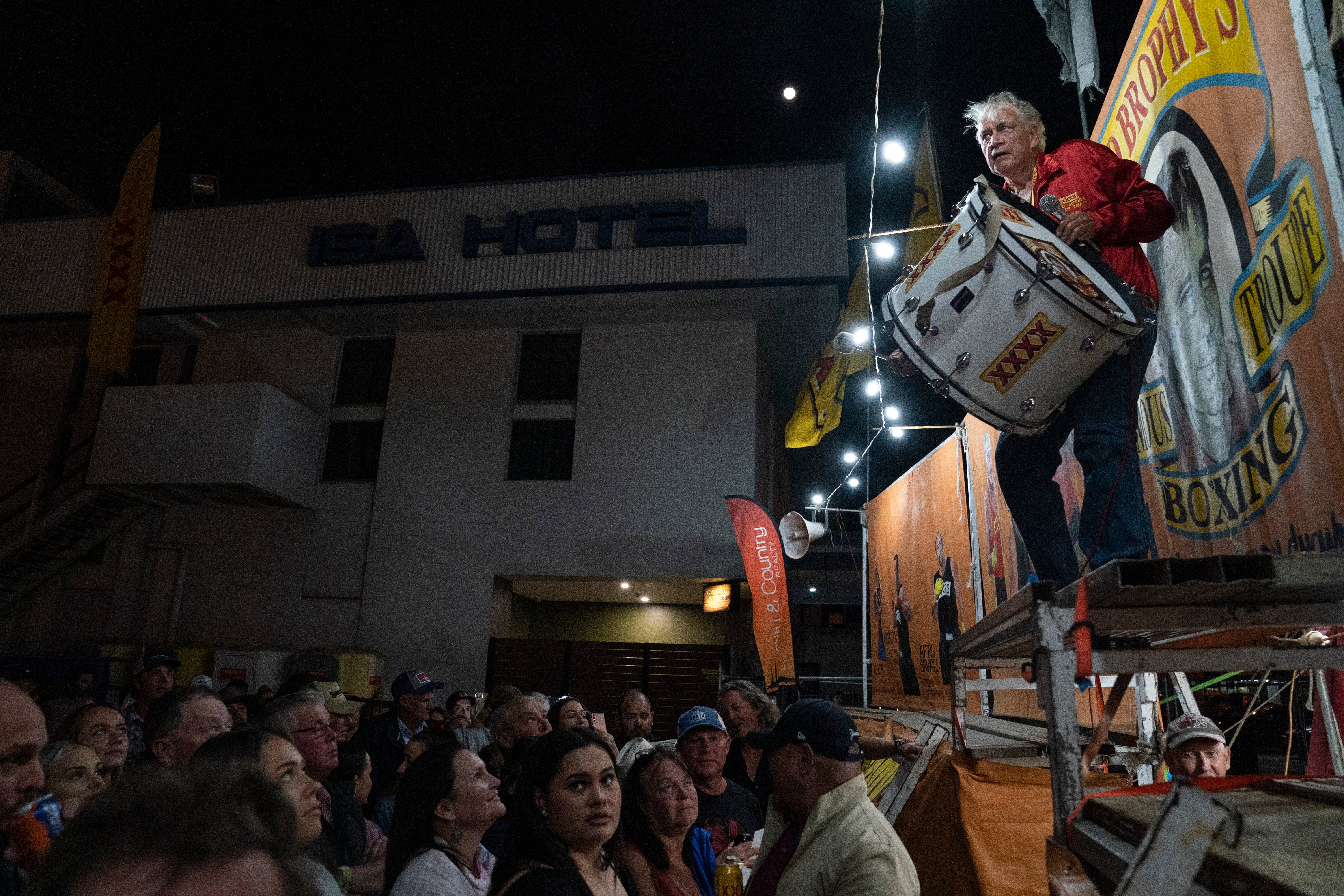 The ‘spruiker’ bangs a drum, announcing his boxers for the night