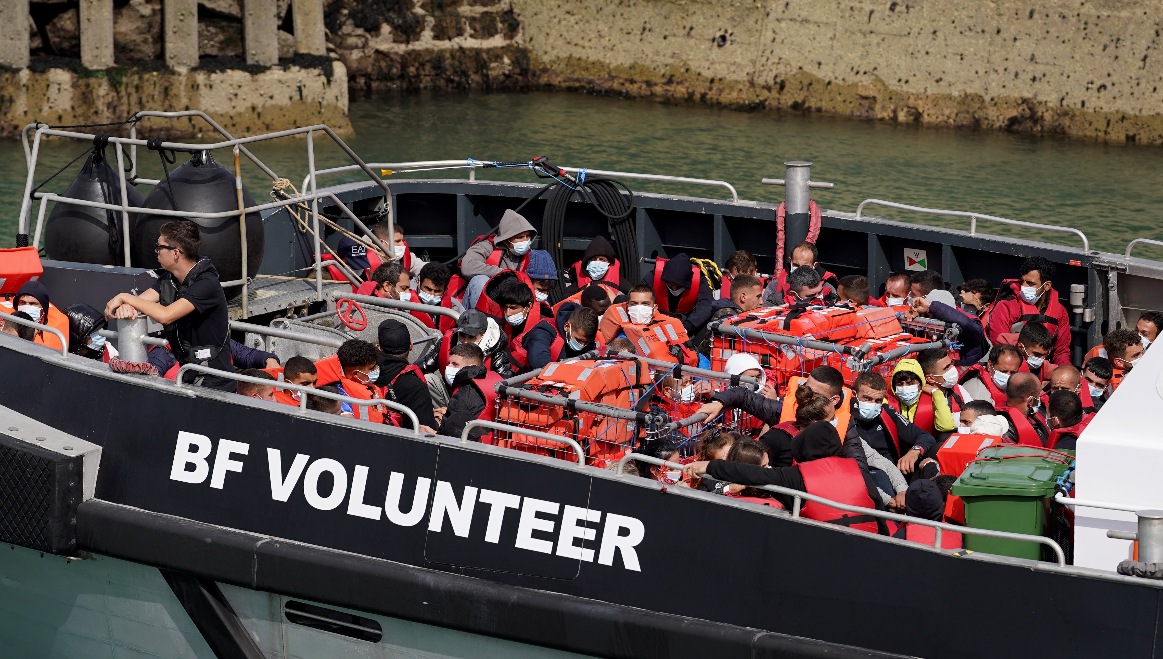 A group of people, thought to be migrants, are taken ashore at Dover on board a Border Force vessel on Sunday