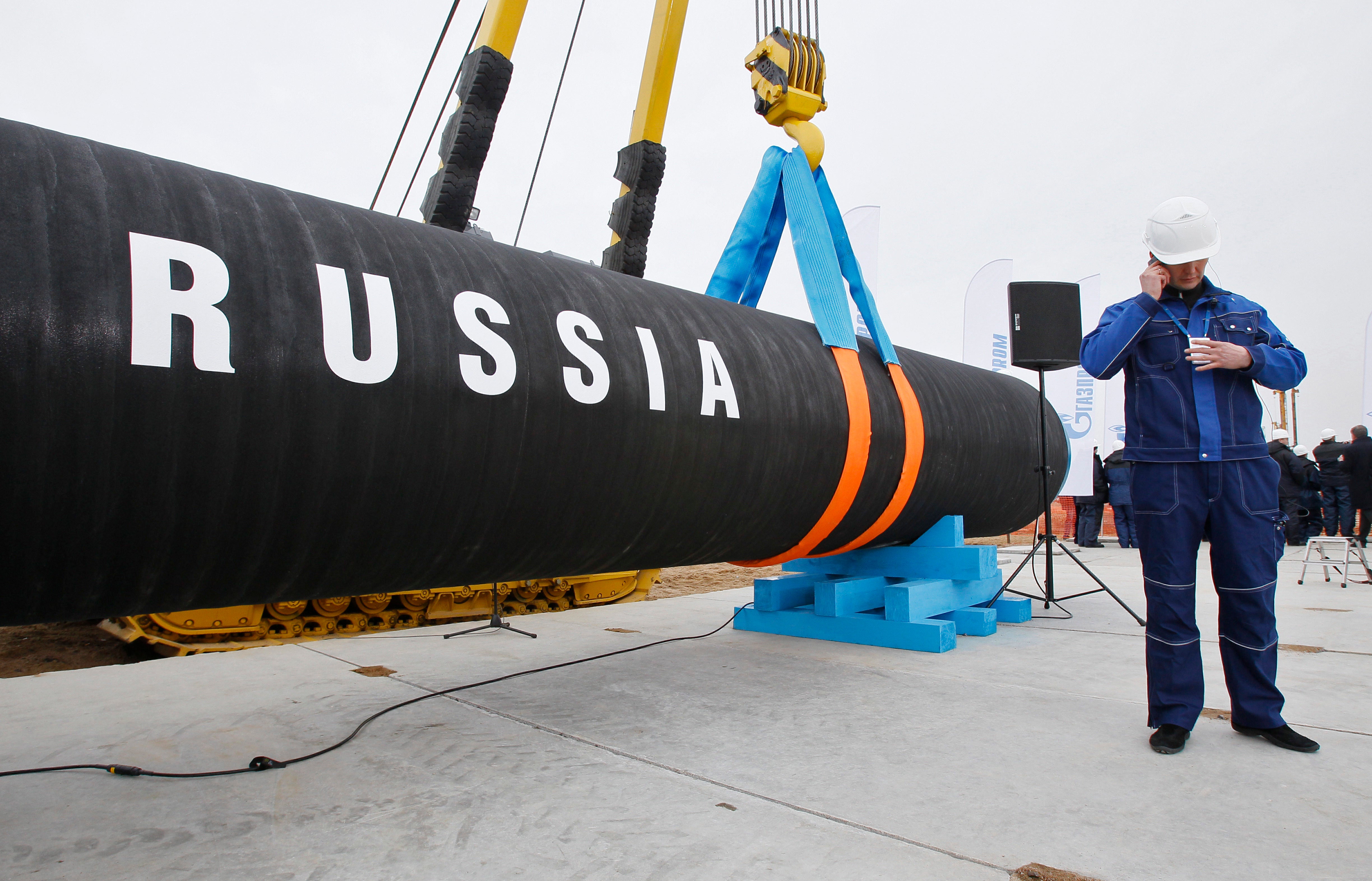 A Russian construction worker speaks on a mobile phone during a ceremony marking the opening of the Nord Stream pipeline in 2010