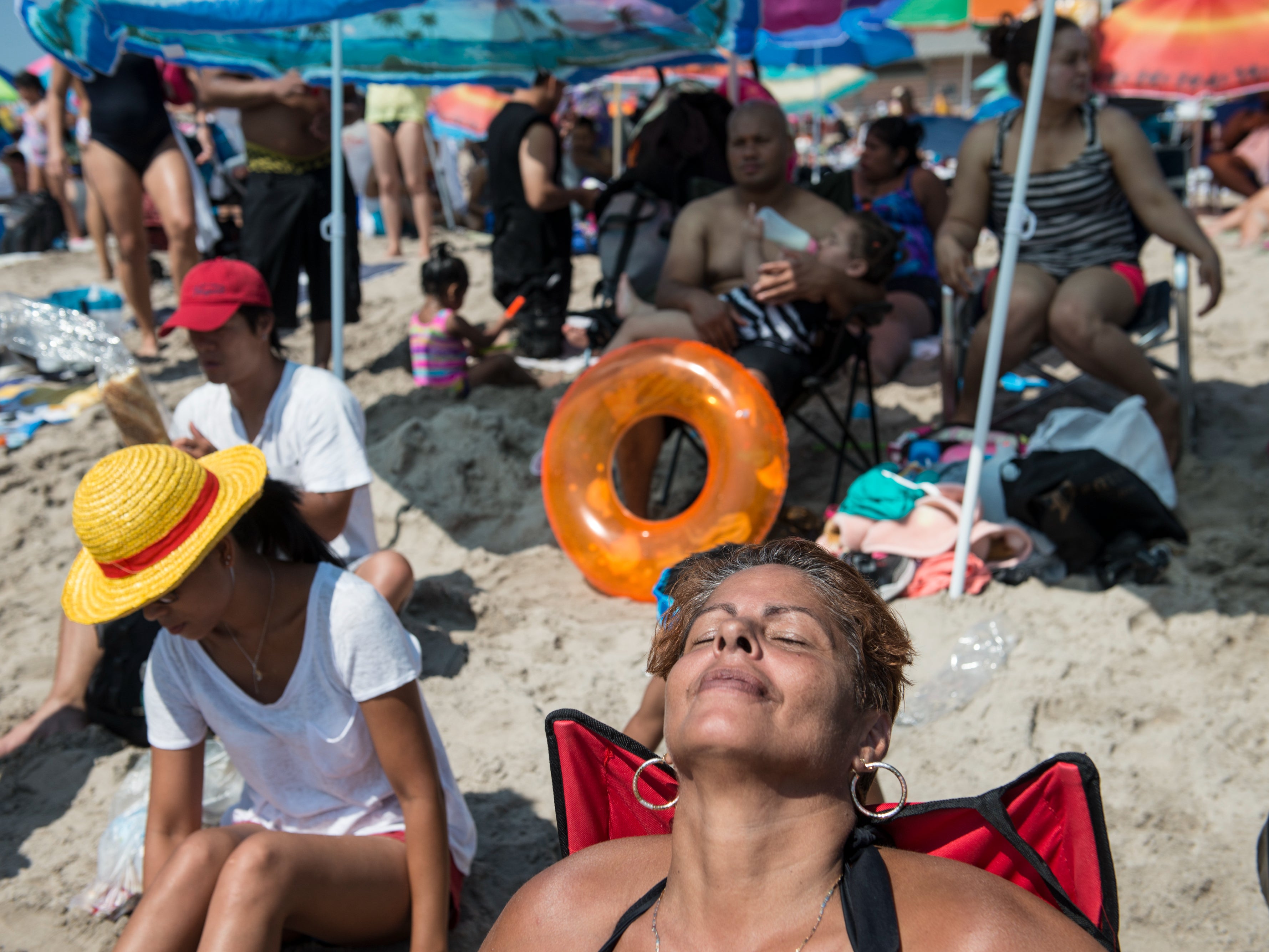 <p>A woman sits at the beach on Labor Day in Coney Island September 7, 2015 in the Brooklyn borough of New York City</p>