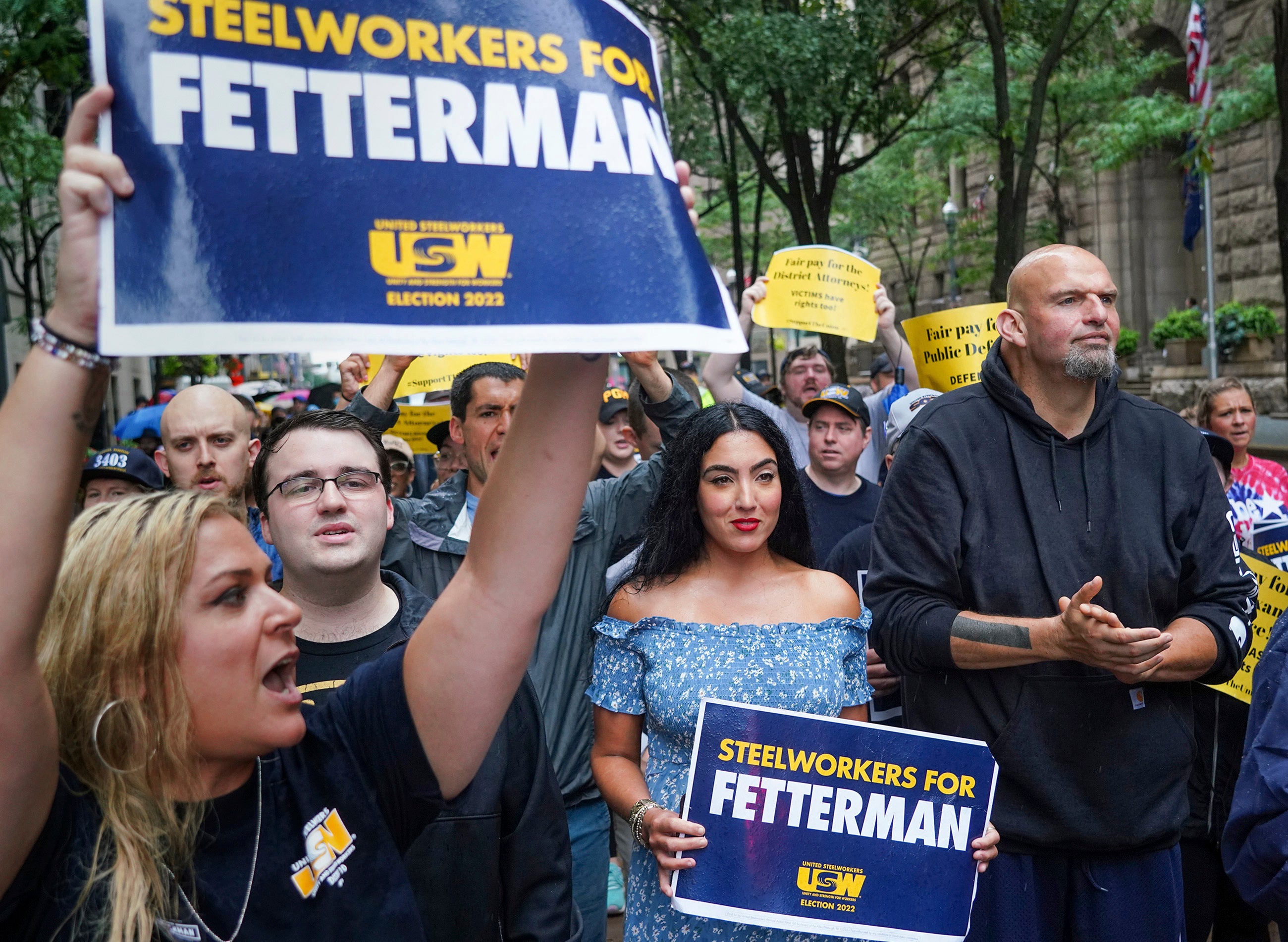 Supporters surround John Fetterman, right, Pennsylvania's Democratic lieutenant governor and senate candidate, during a Labor Day parade in downtown Pittsburgh, on 5 September. His wife, Gisele, in a blue dress holds a sign next to him