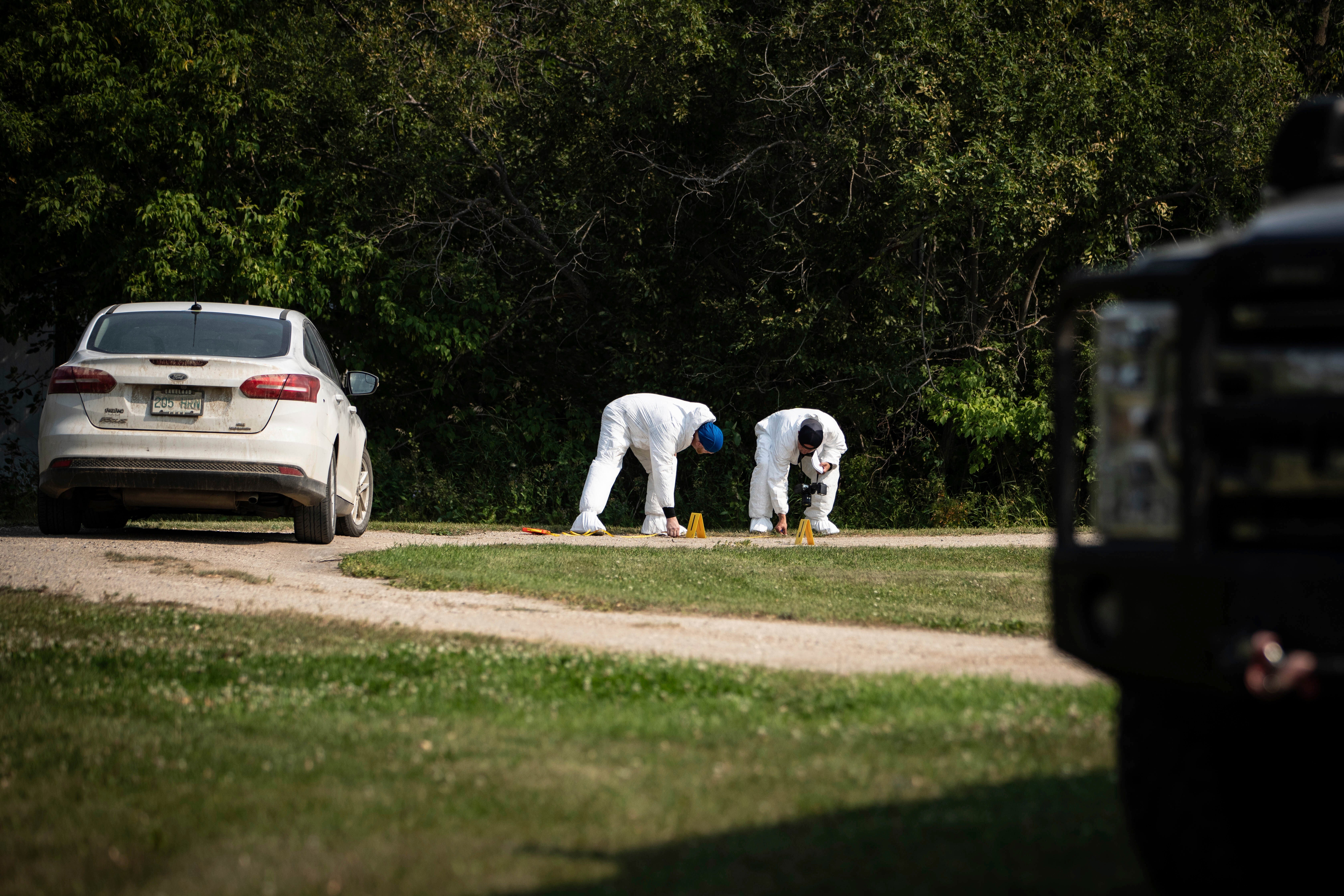 Investigators examine the crime scene outside the home of Wes Petterson in Weldon, Saskatchewan, Monday, Sept. 5, 2022