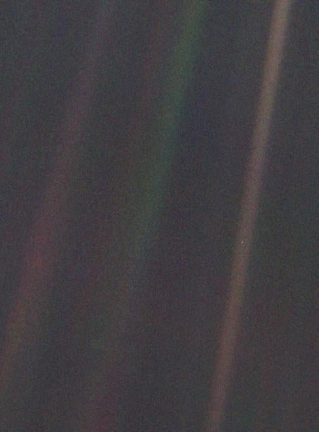 Earth is seen as a mote in an orange shaft of sunlight in this image taken by the Voyager 1 spacecraft in 1990 from a vantage point 40 times further from the Sun that the Earth.