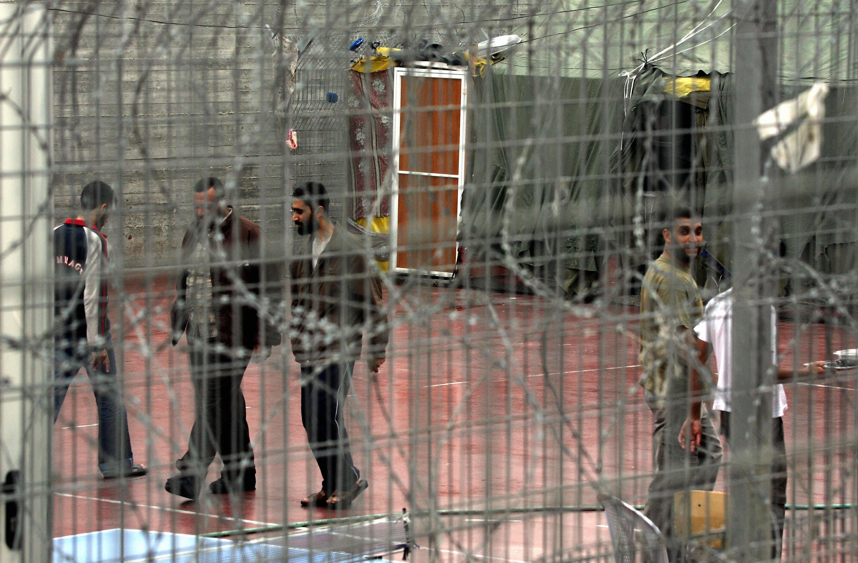 Palestinian prisoners walk at the yard of Megiddo prison where administrative detainees are held