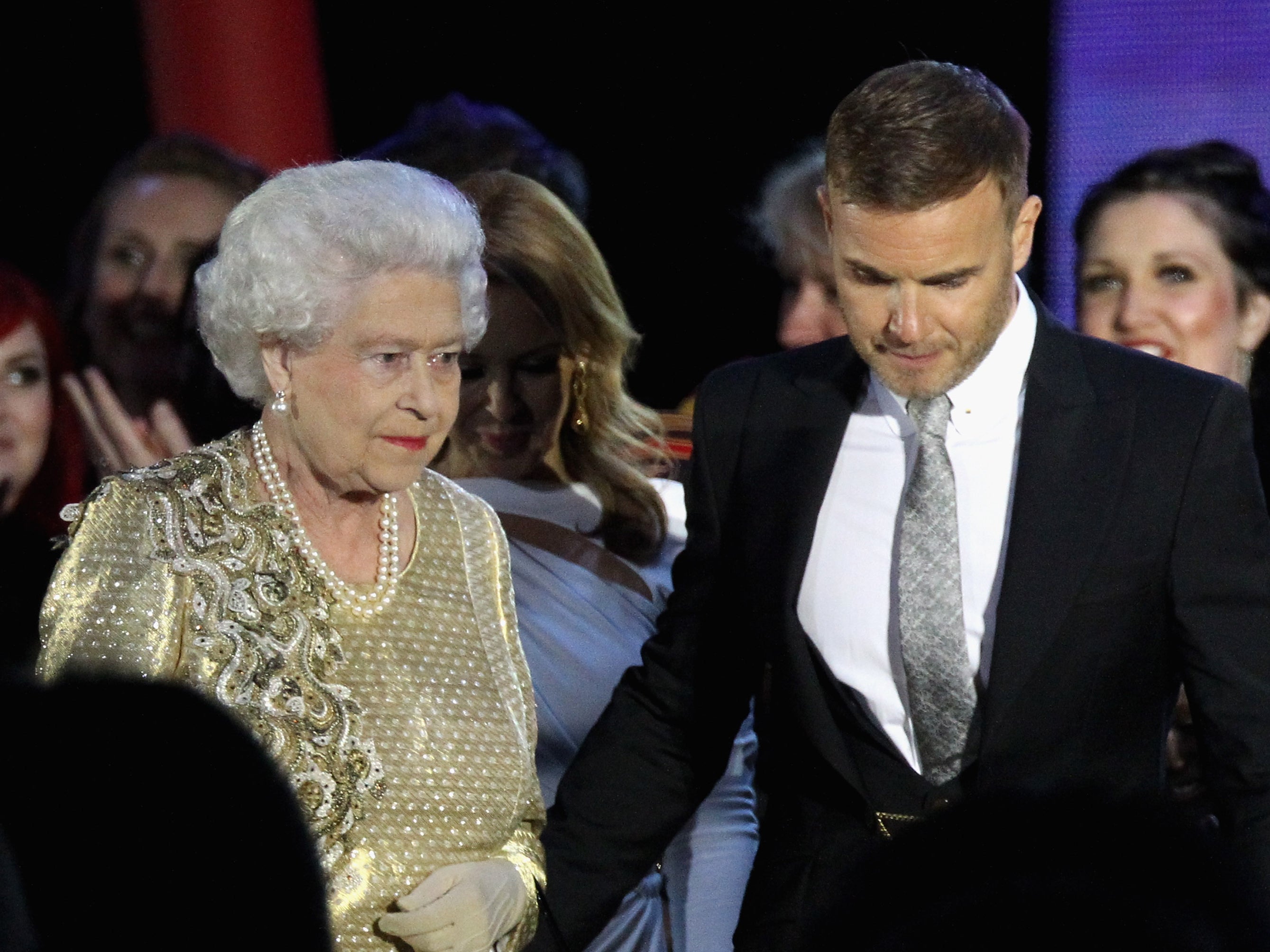 Queen Elizabeth andmusician Gary Barlow on stage during the Diamond Jubilee concert at Buckingham Palace on June 4, 2012