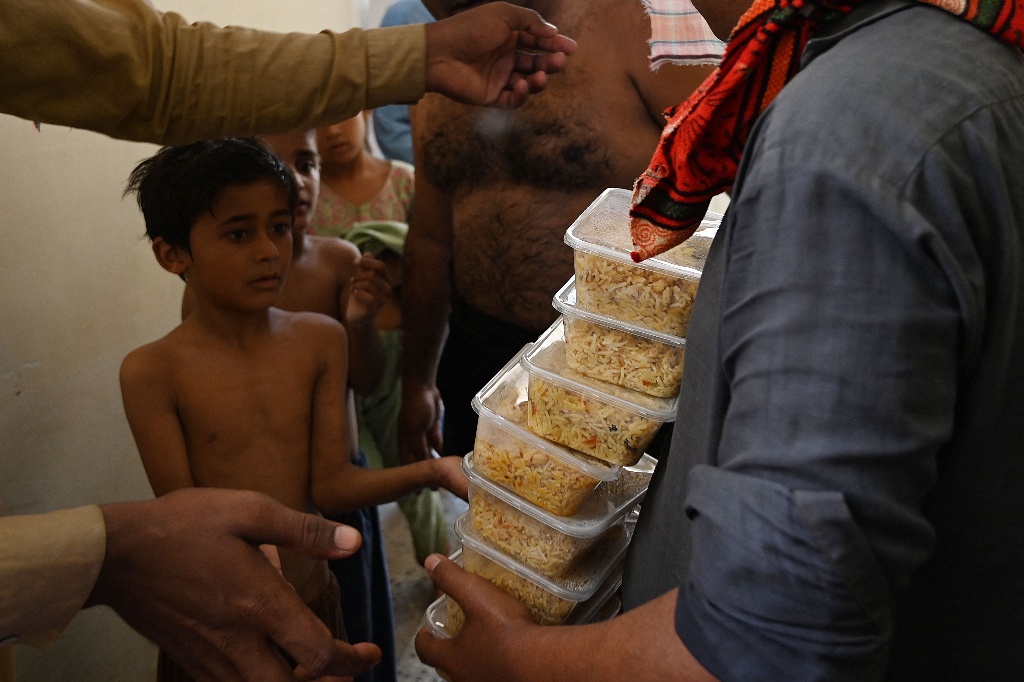 A boy waits to receive food packets provided by local authorities