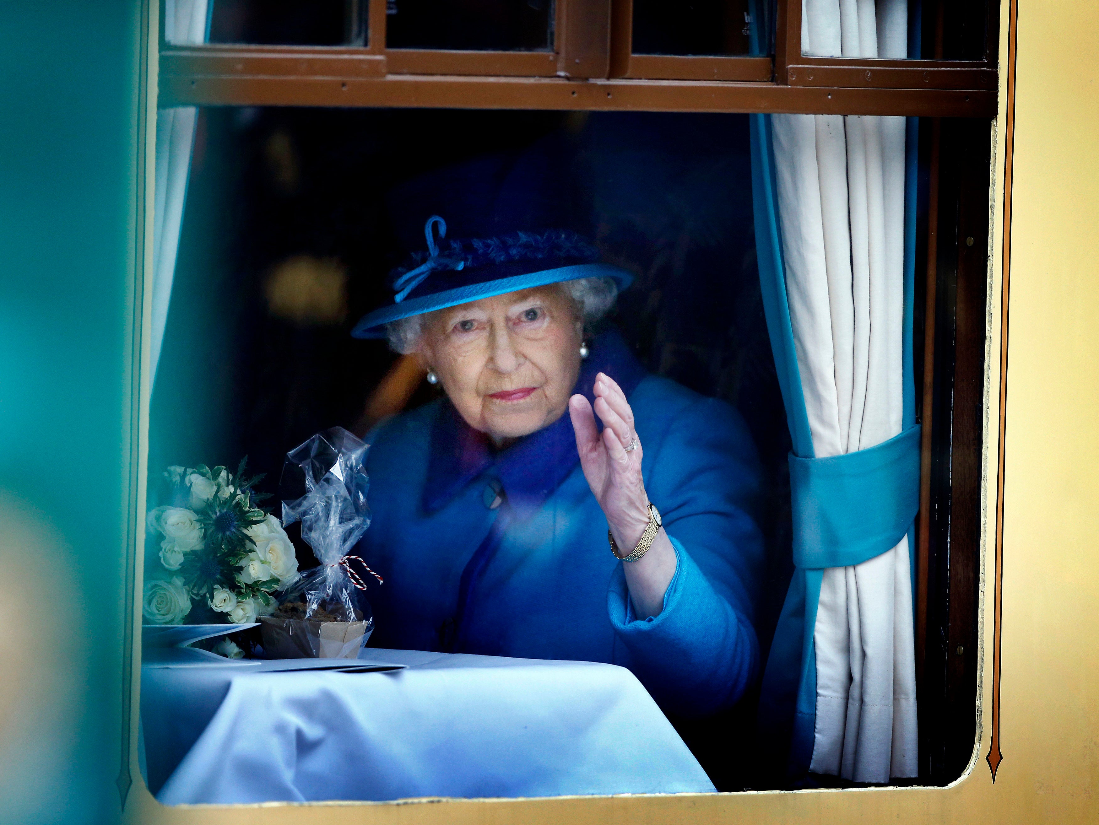 The Queen, on the day she became Britain’s longest reigning monarch, waves from a carriage window at Edinburgh’s Waverley Station (Danny Lawson/PA)